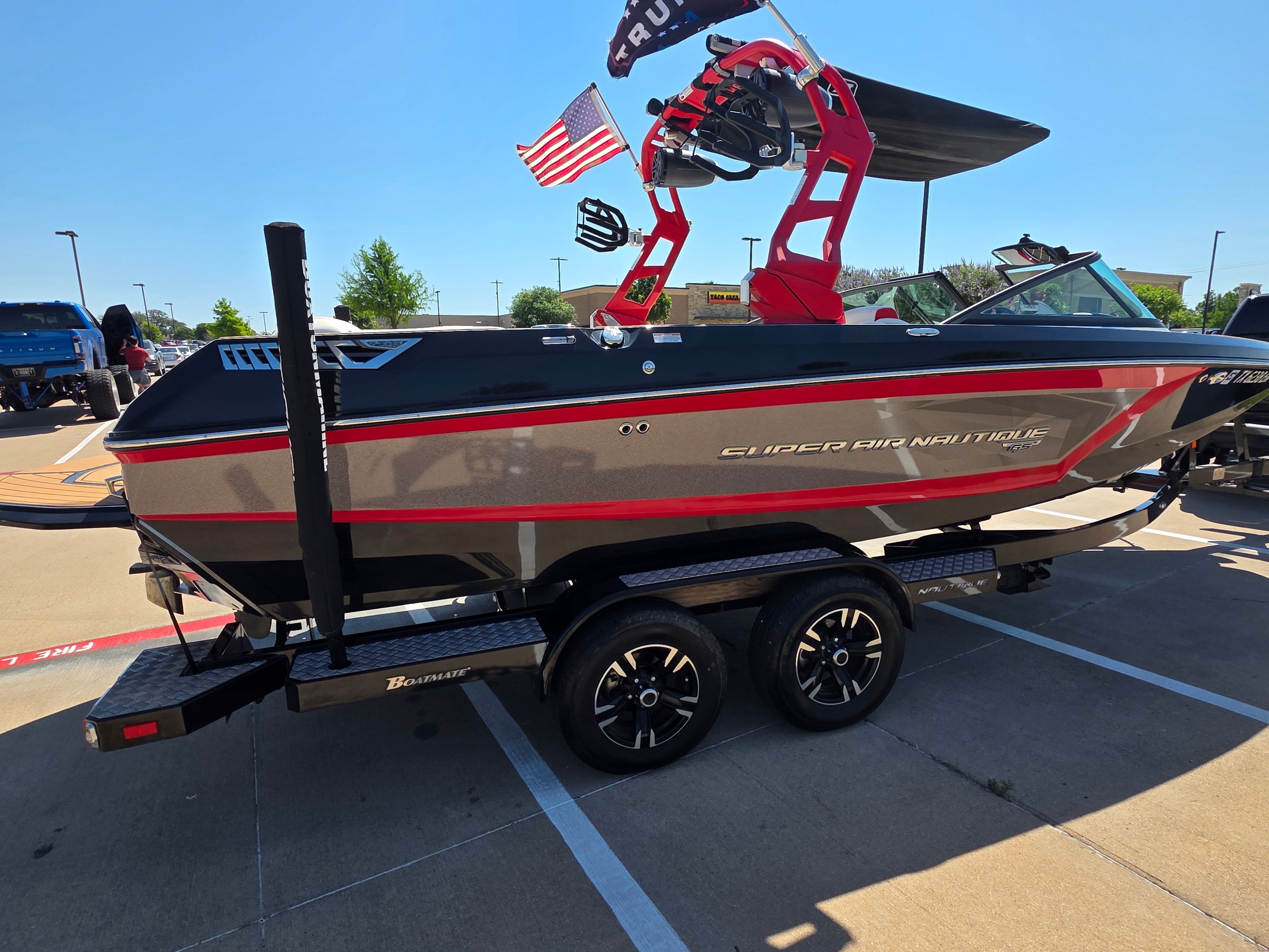 2019 Nautique Super Air Nautique GS22 on a parking lot. It features a sleek design with a tower.