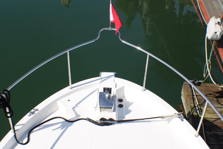 Bow view of 2019 Ranger Tugs R-31 CB boat with railing and flag.