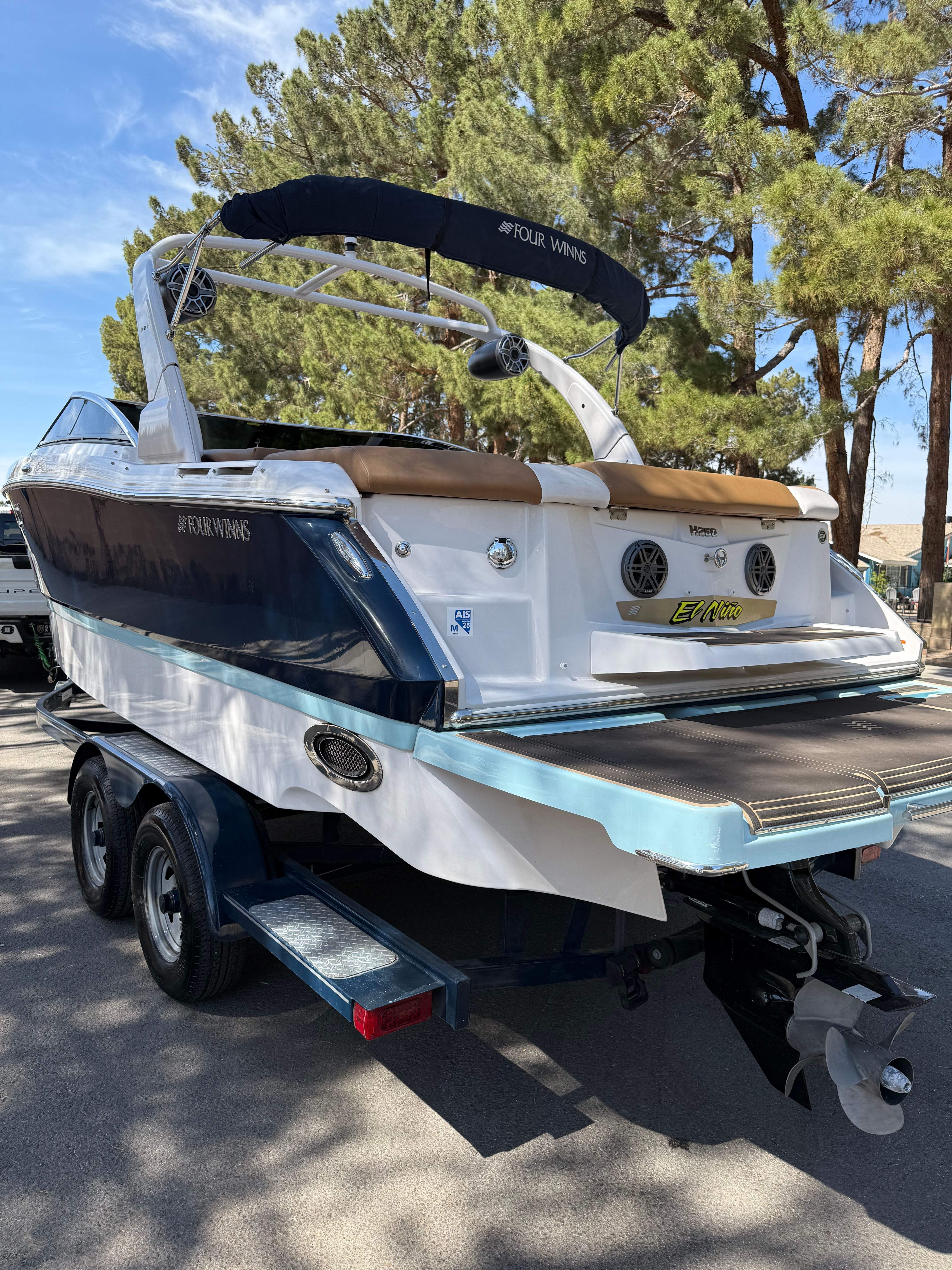 2019 Four Winns H260 boat on trailer, parked outdoors.