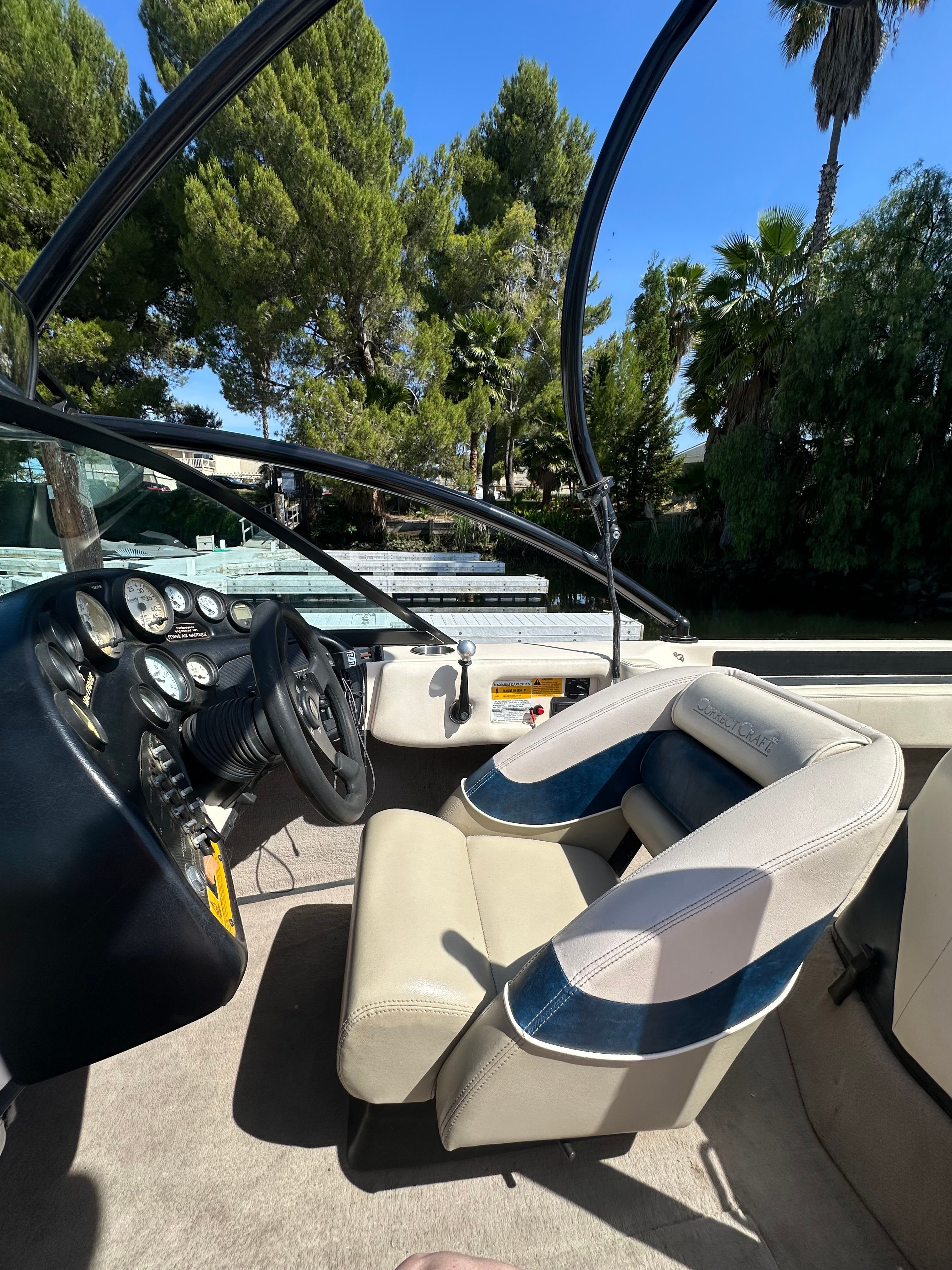 Interior of a 1998 Correct Craft Air Nautique boat with steering and seats.