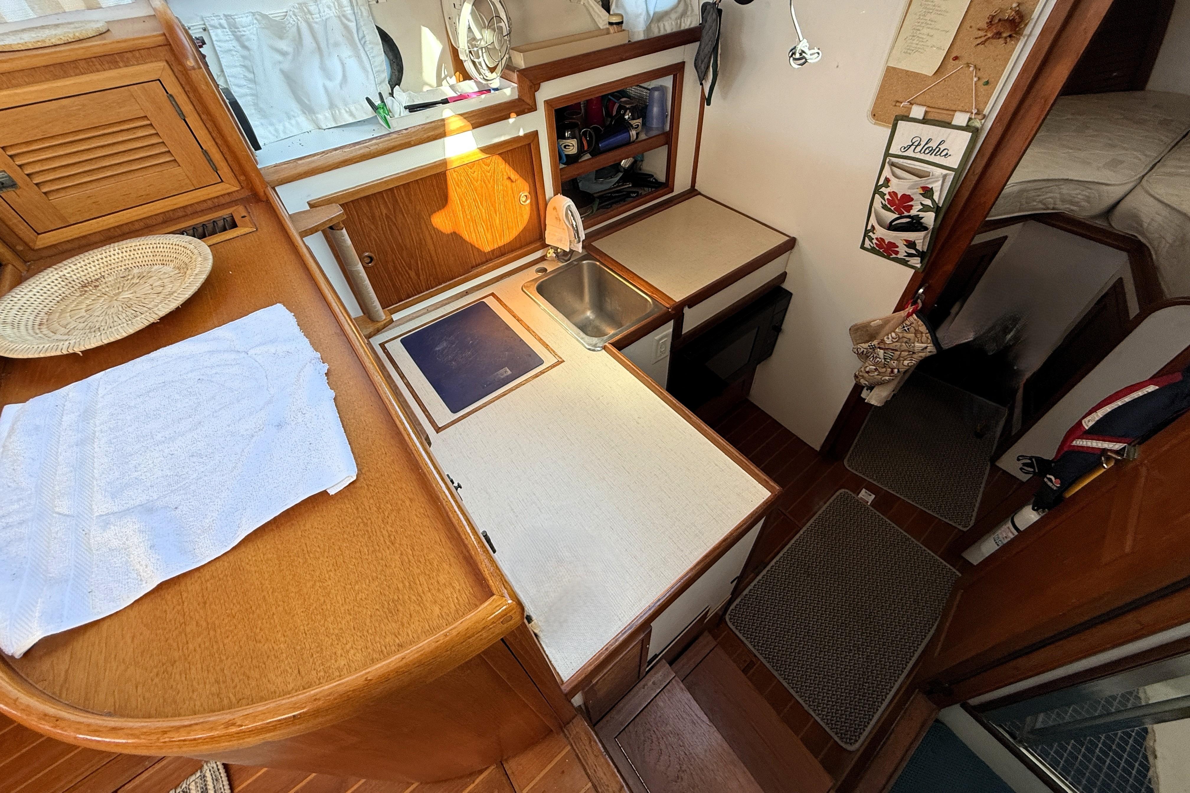 1983 Wilbur 34 Fly Bridge Cruiser interior with compact kitchen and cozy cabin space.