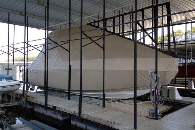 Covered 1999 Formula 400 Super Sport boat in dock storage under a metal roof.