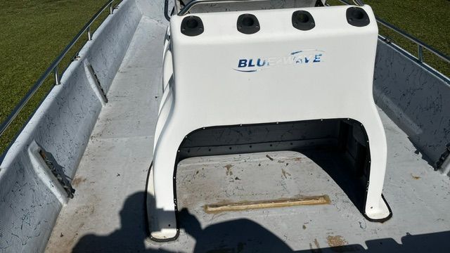 The boat features a white console with four cup holders.