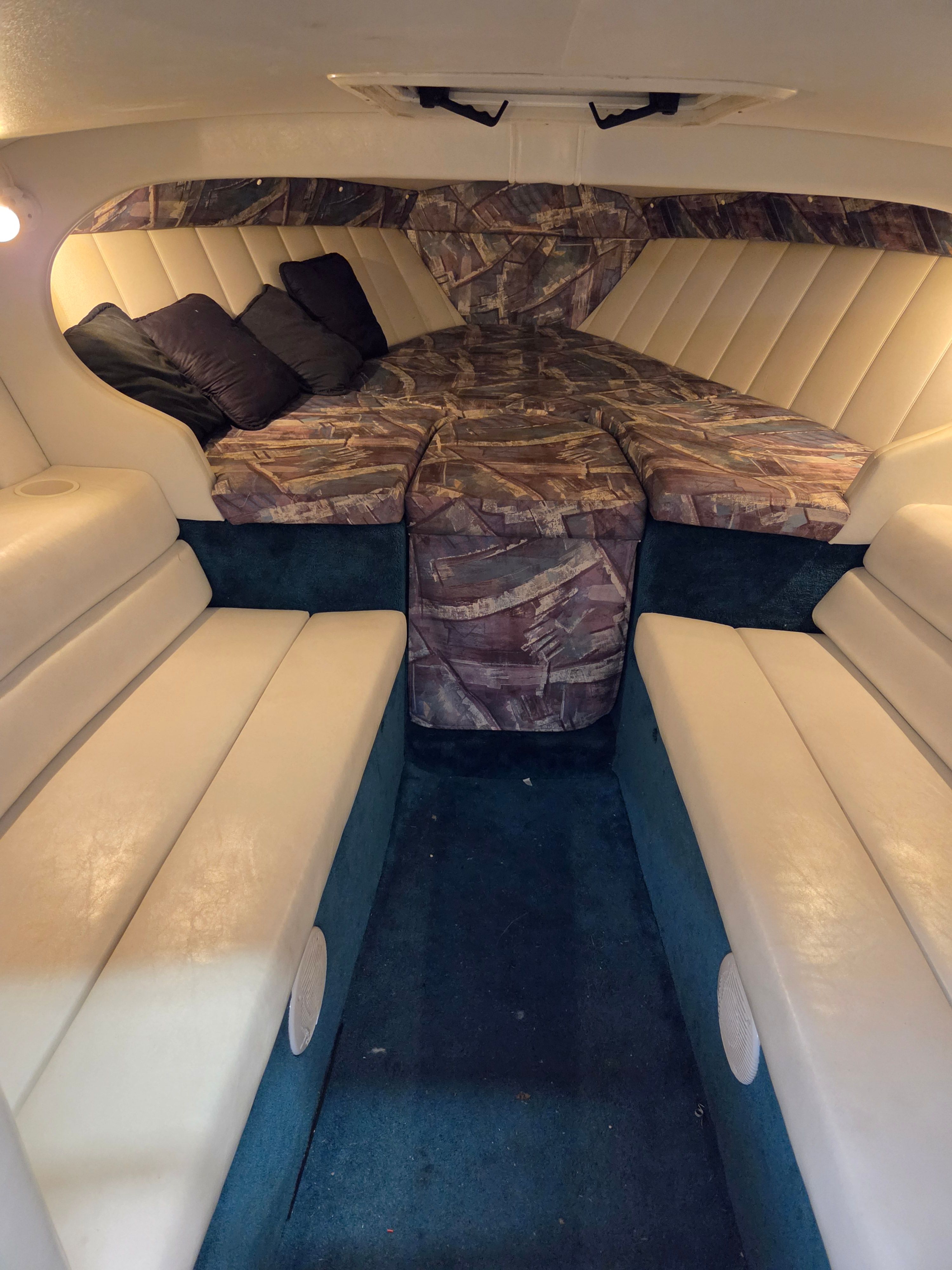 Interior of a 1998 Powerquest Enticer 290 FX with cushioned seating and sleeping area.