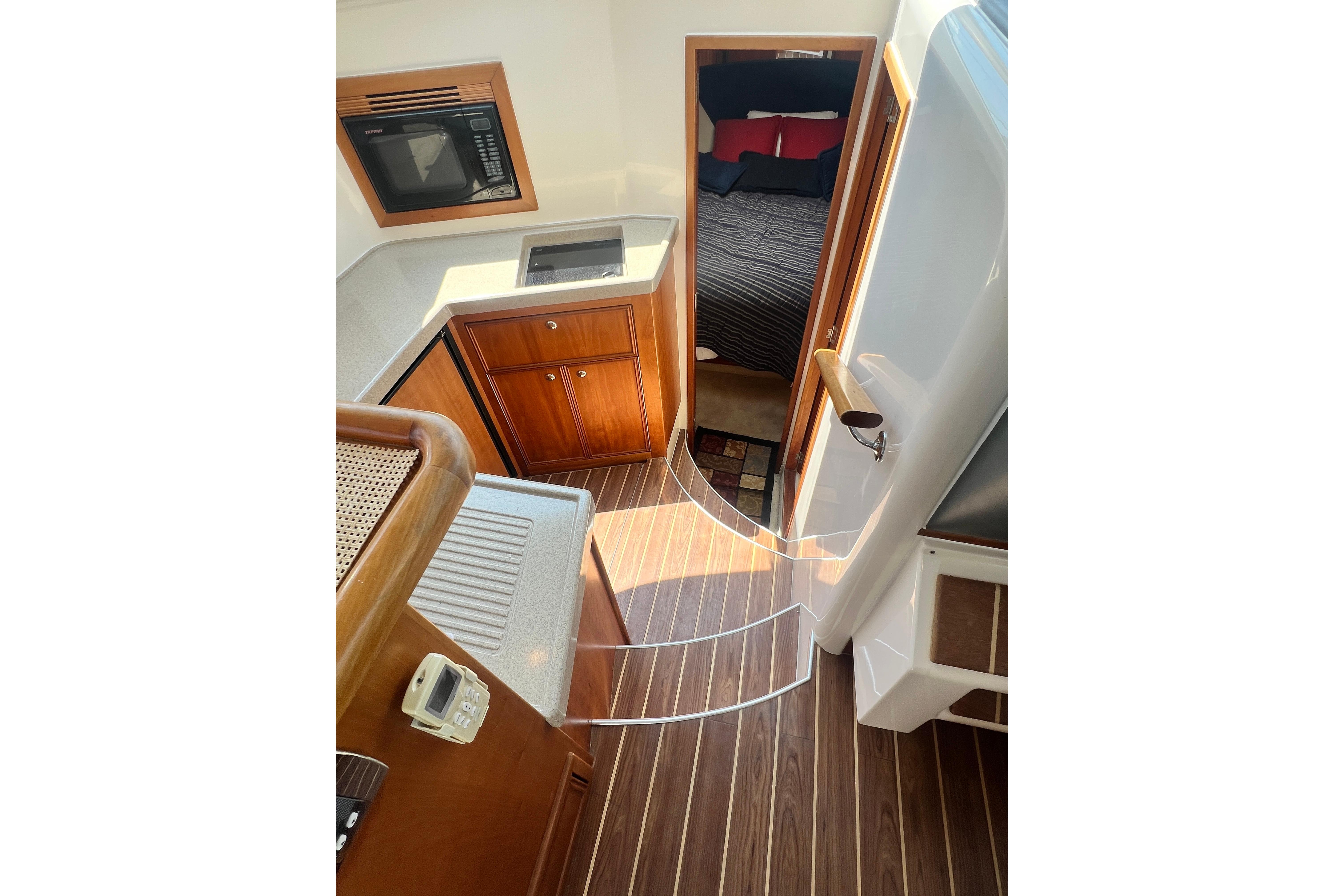 Interior of 2007 Riviera 33 Flybridge yacht with kitchen and bedroom view.