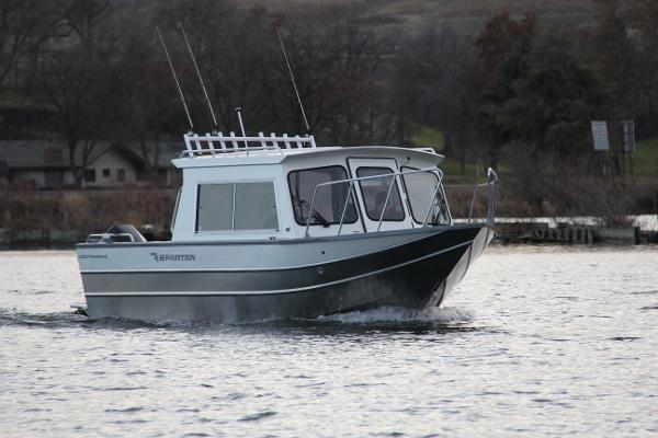 2023 Spartan 220 Maximus Pro boat cruising on a lake.