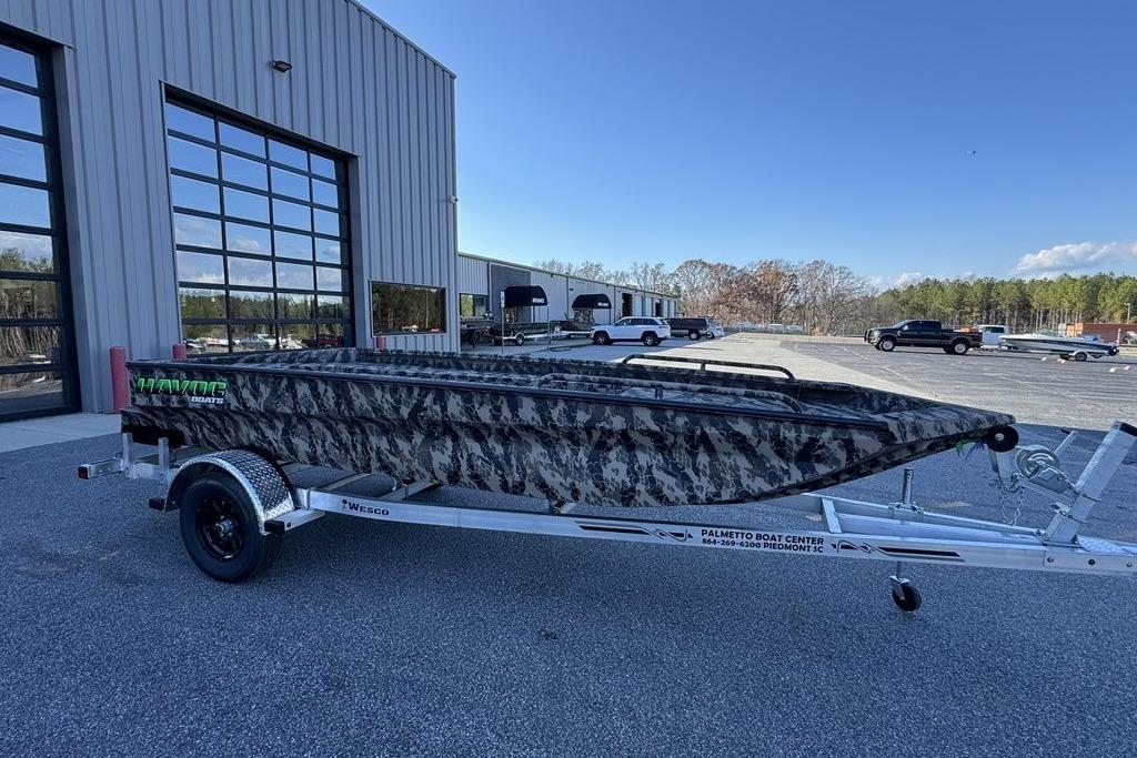 2025 Havoc 1860 boat with camouflage design on a trailer at a dealership.