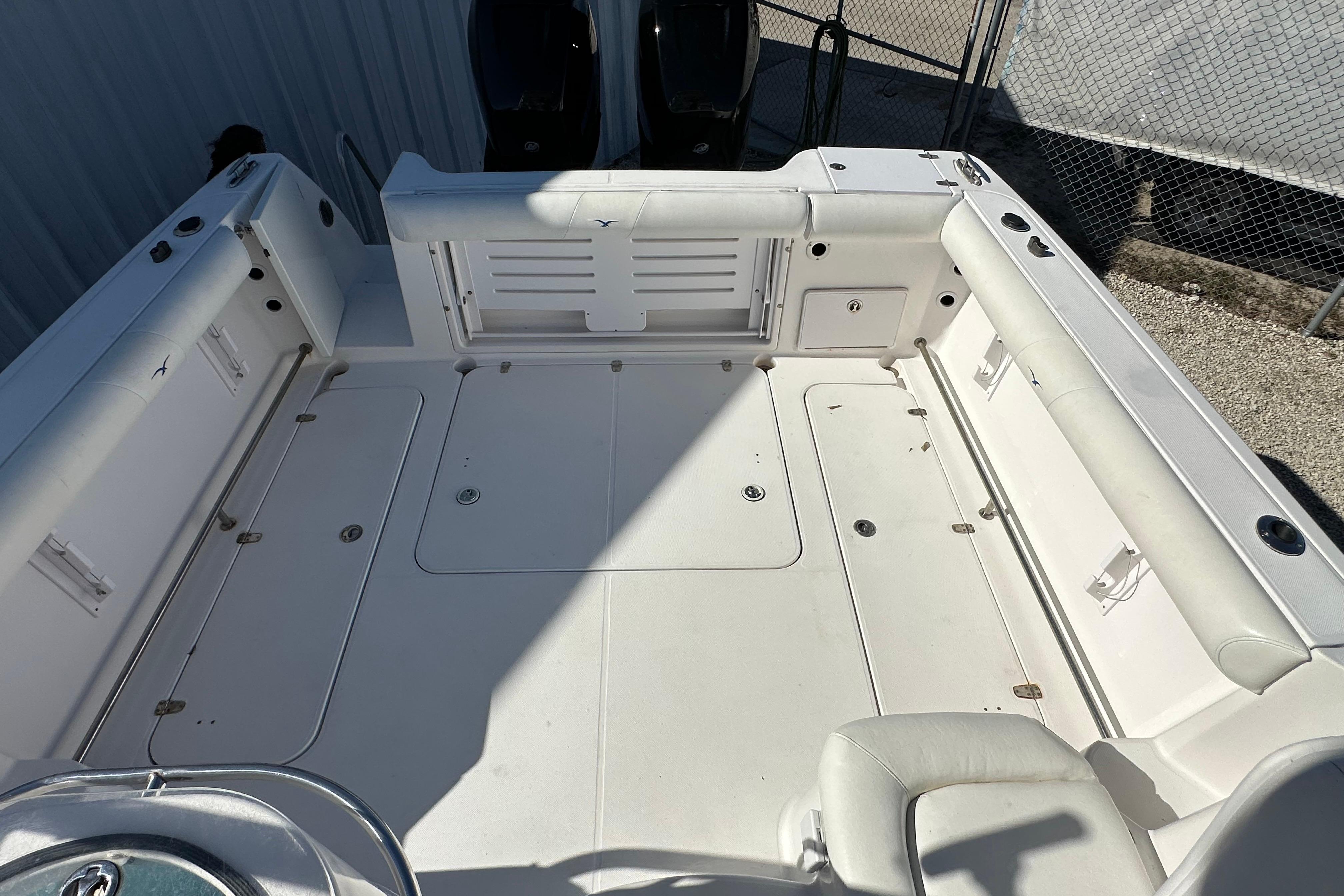 2006 Pro-Line 32 Express boat deck with white seating and storage compartments.