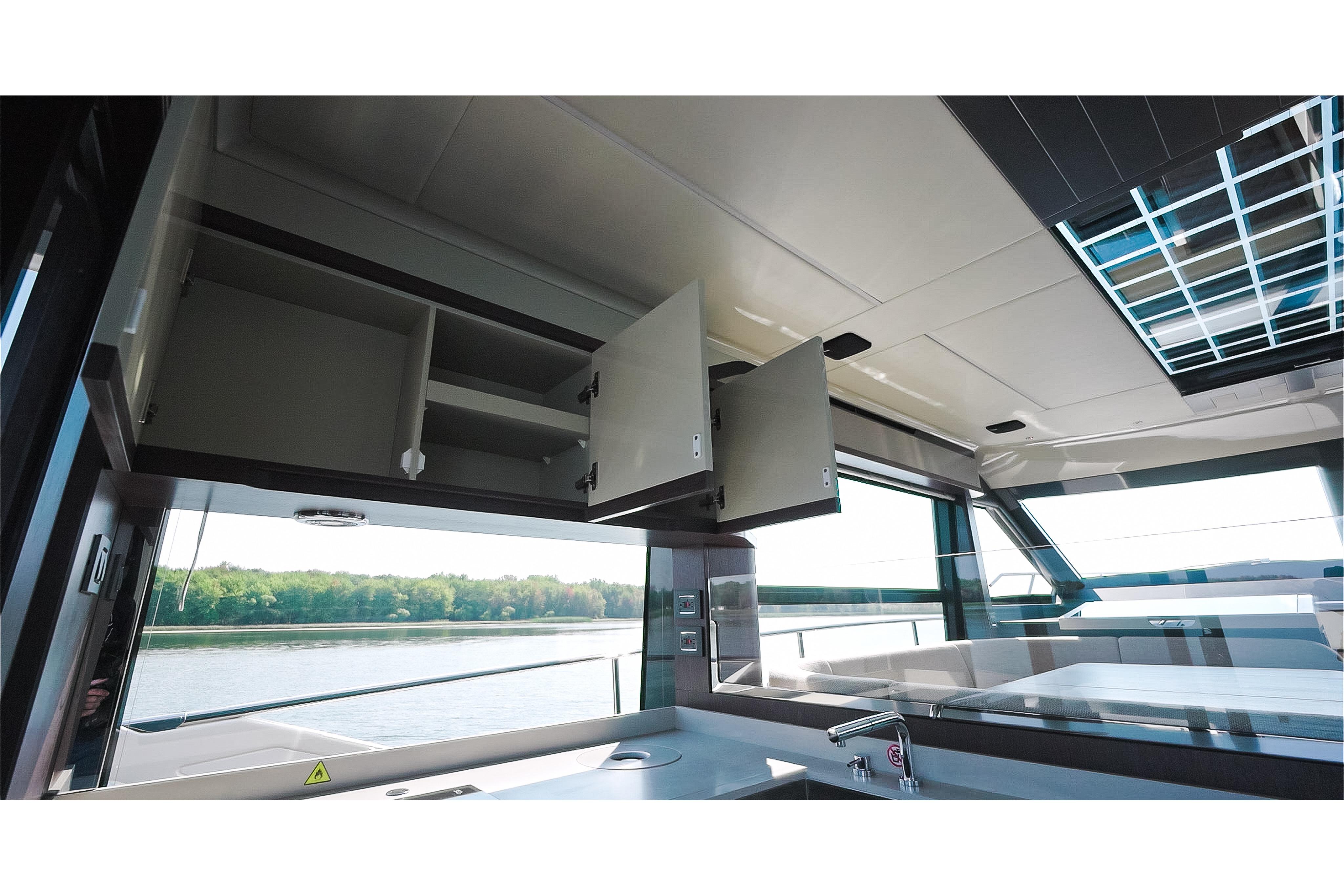 Interior of 2026 Absolute 48 Coupe yacht with open cabinets and scenic water view.
