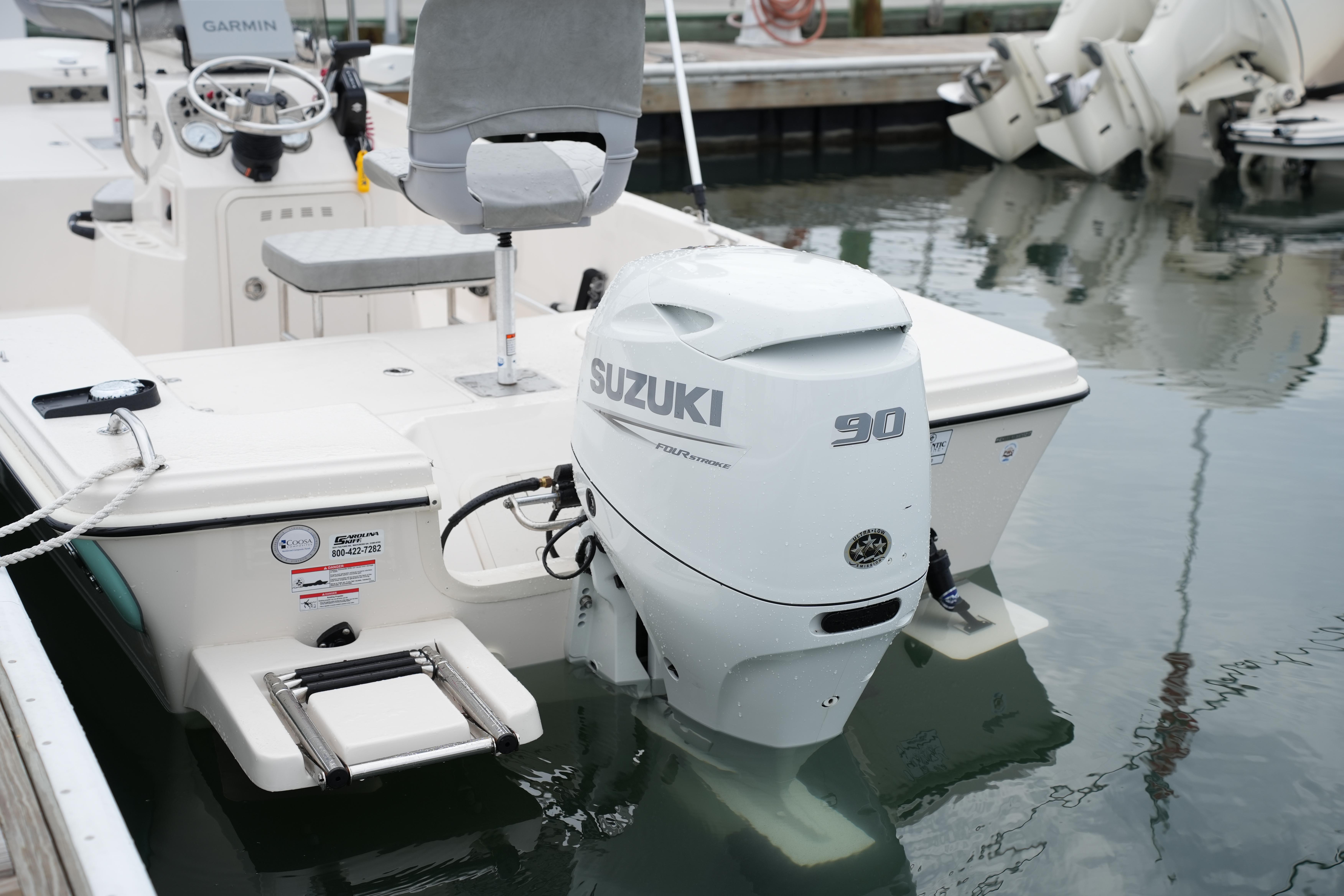 2025 Carolina Skiff 162 JLS with Suzuki 90 outboard motor docked in marina.