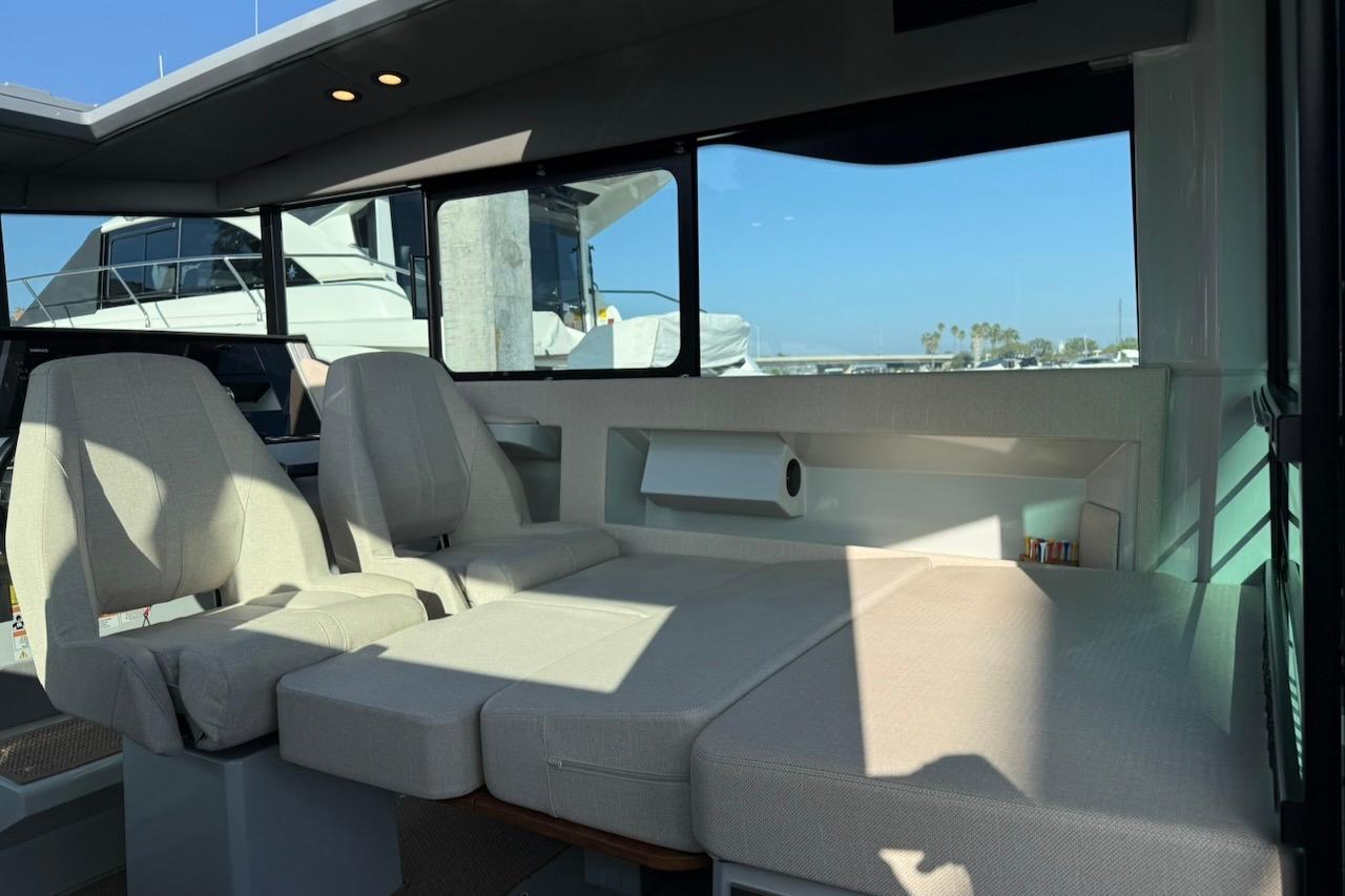 Interior of 2024 Saxdor 320 GTC boat with beige seating and large windows.