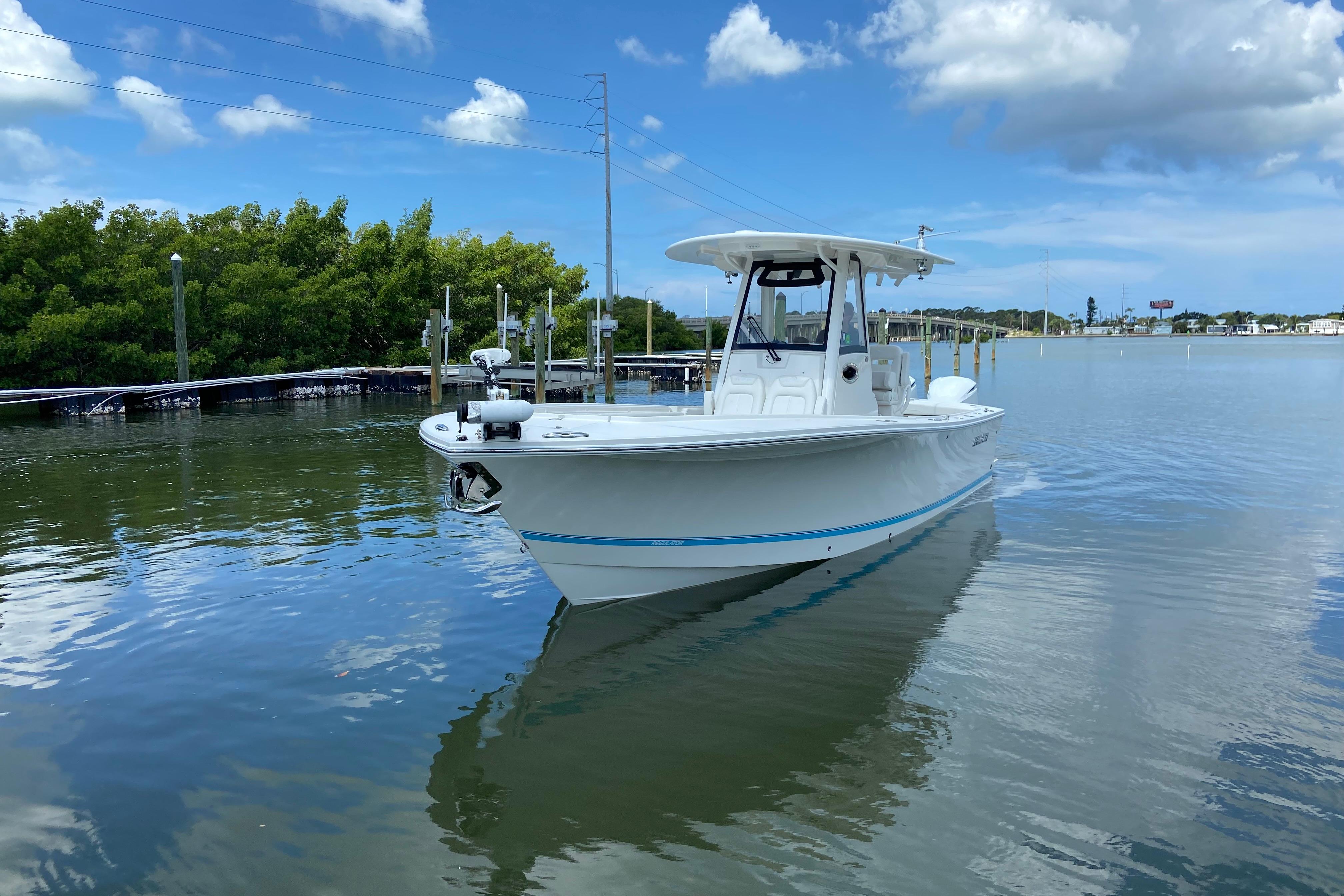 2021 Regulator 28 boat on calm water under a partly cloudy sky.