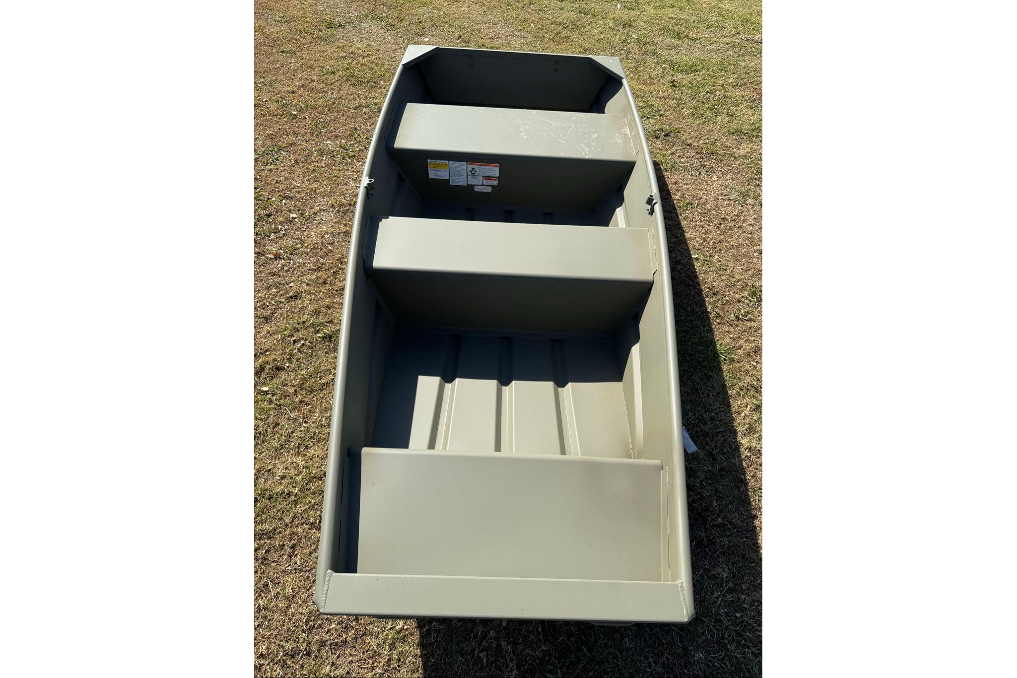 2026 Tracker Grizzly 10 Jon boat on grass, showcasing interior seating and design.