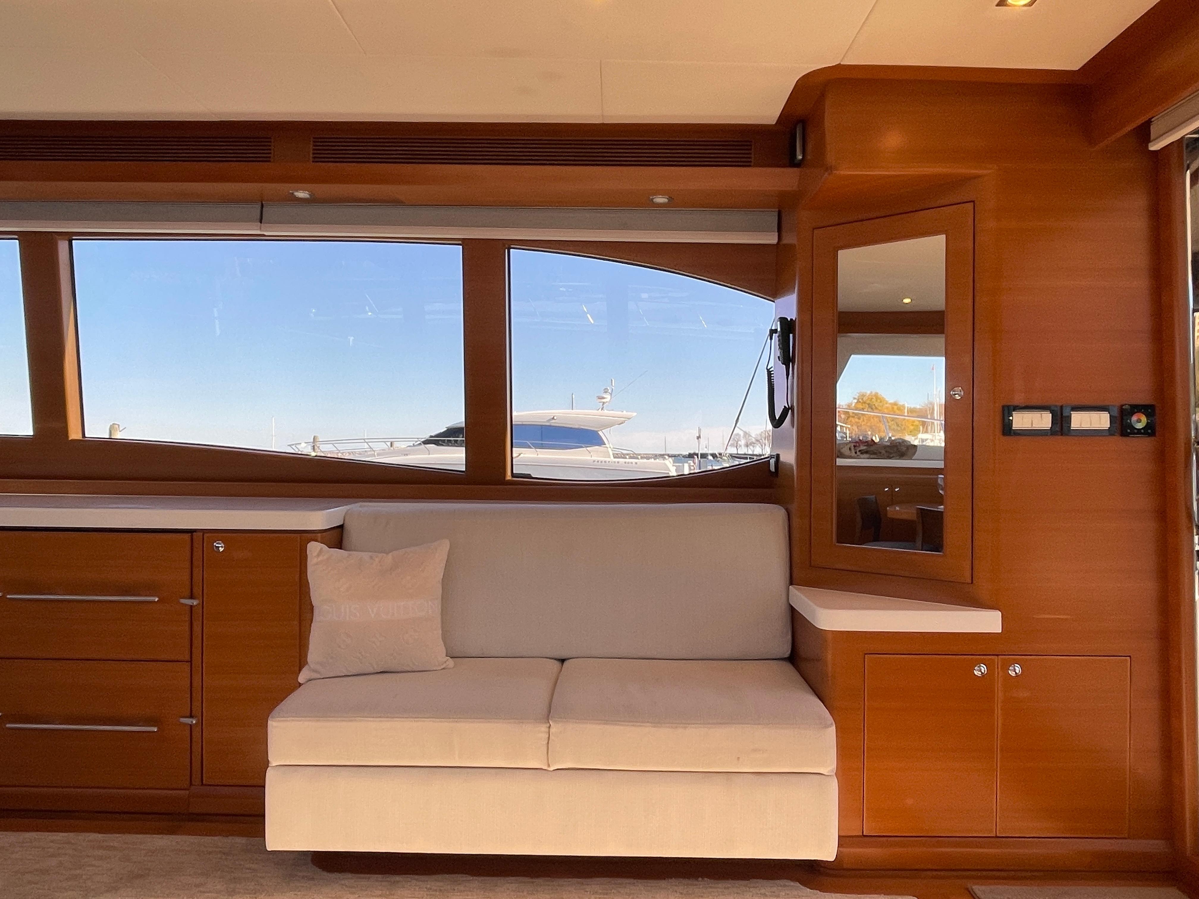 Interior of 2014 Nordhavn 60 Toro Convertible yacht with wooden cabinetry and beige sofa.