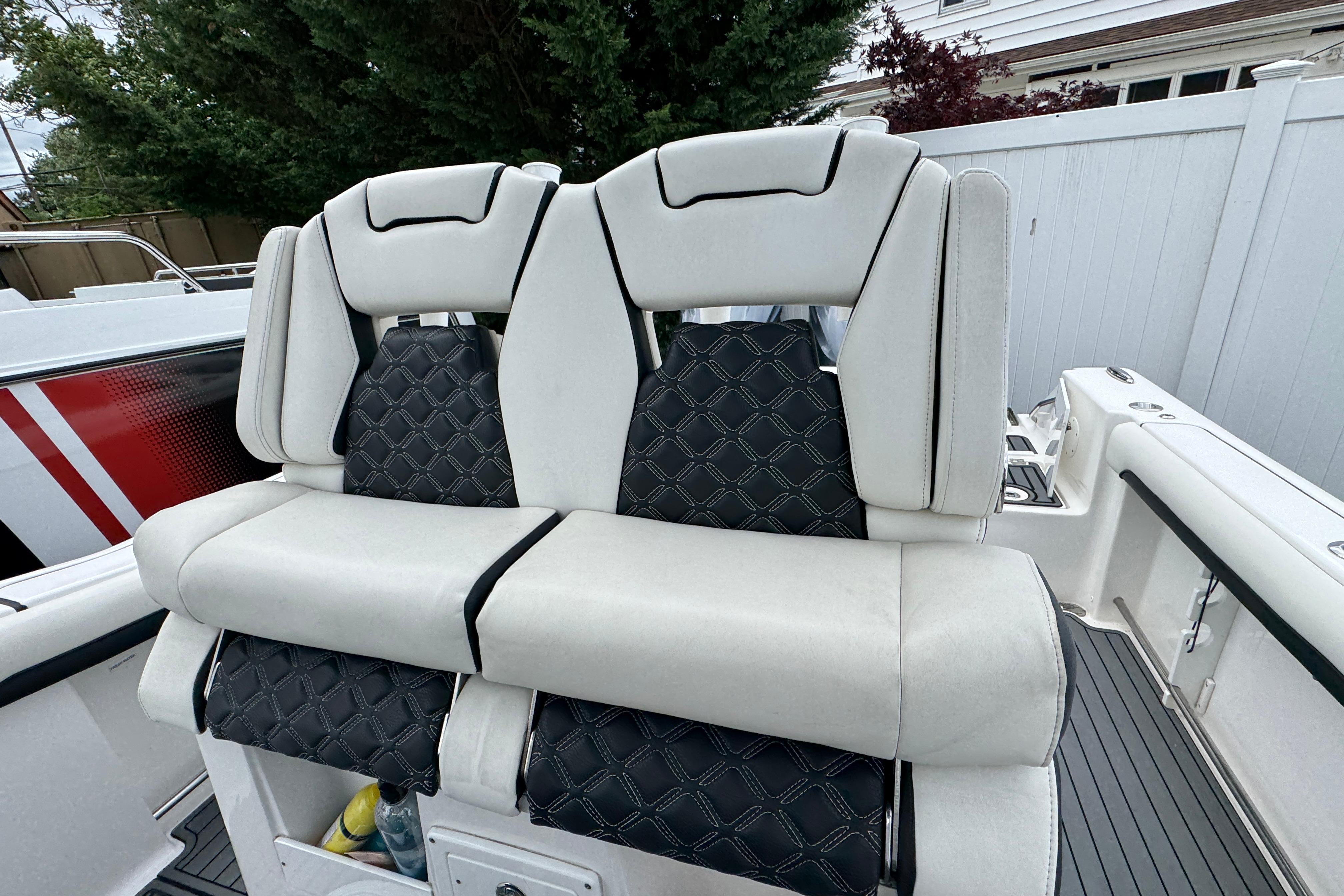 Luxury seating on 2021 Tidewater 280 CC Adventure boat, featuring elegant white and black upholstery.