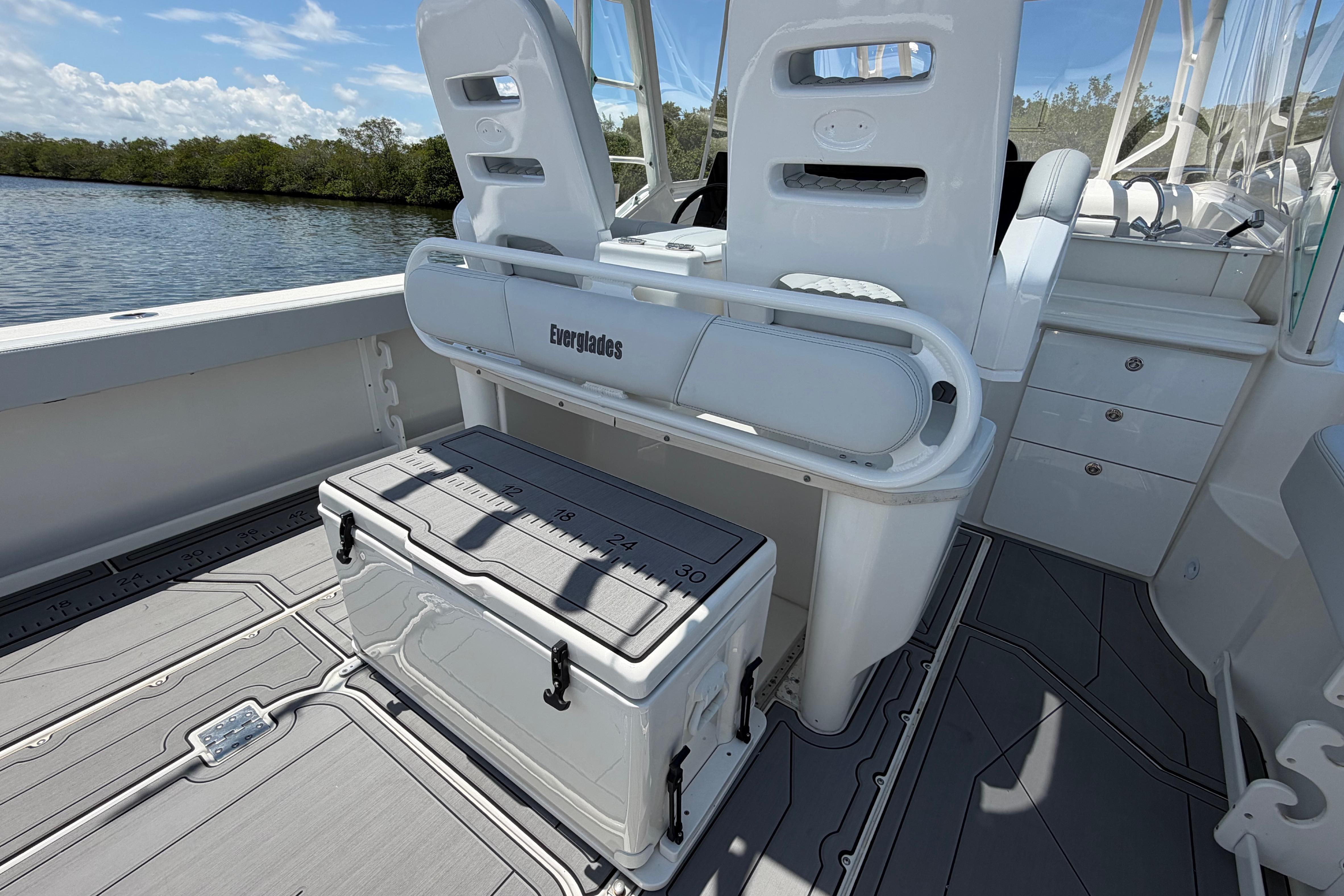 2009 Everglades 350LX boat interior with seating and storage, docked by a scenic waterway.