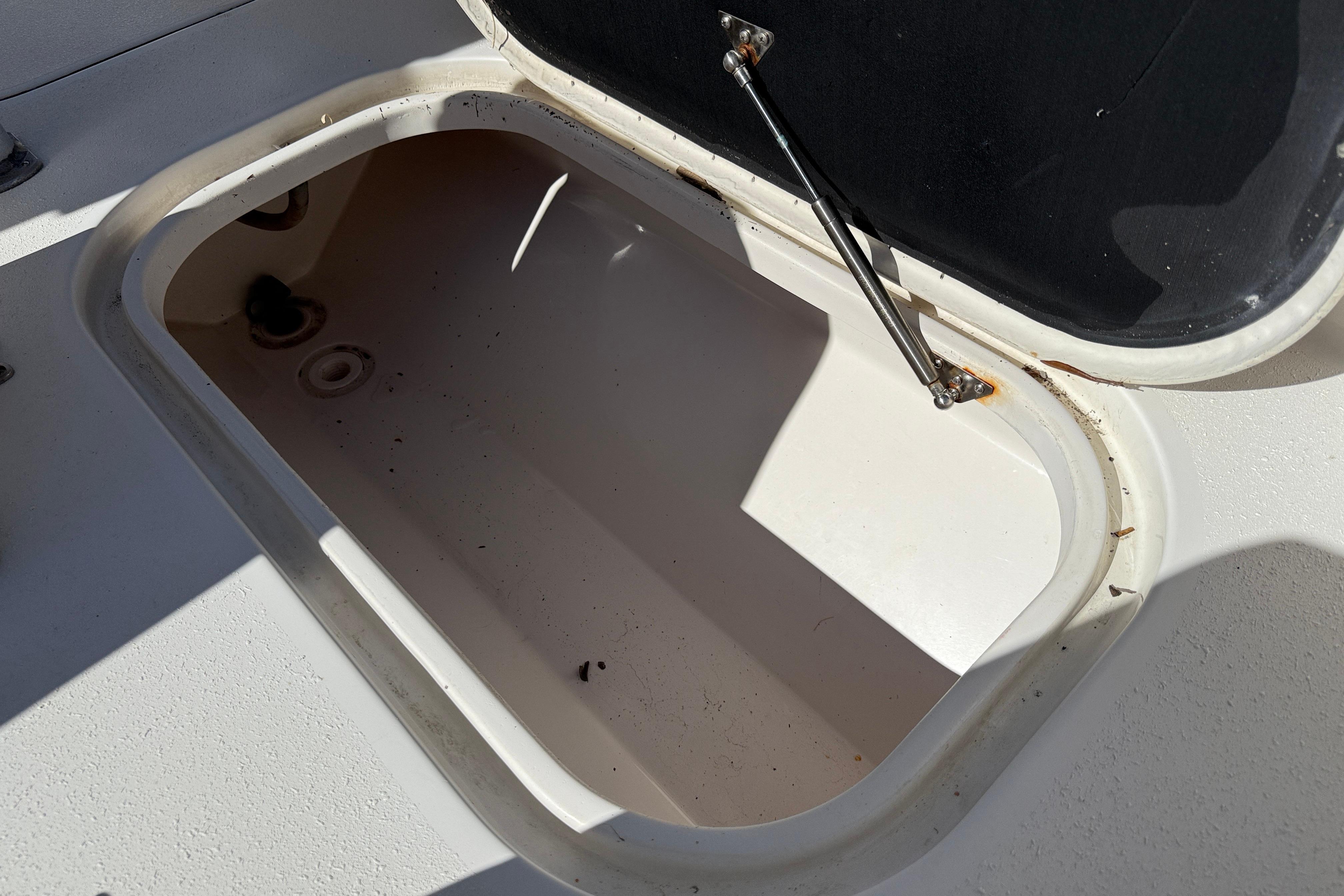Open storage compartment on 2020 Tideline 235 Hybrid boat, showing interior details.