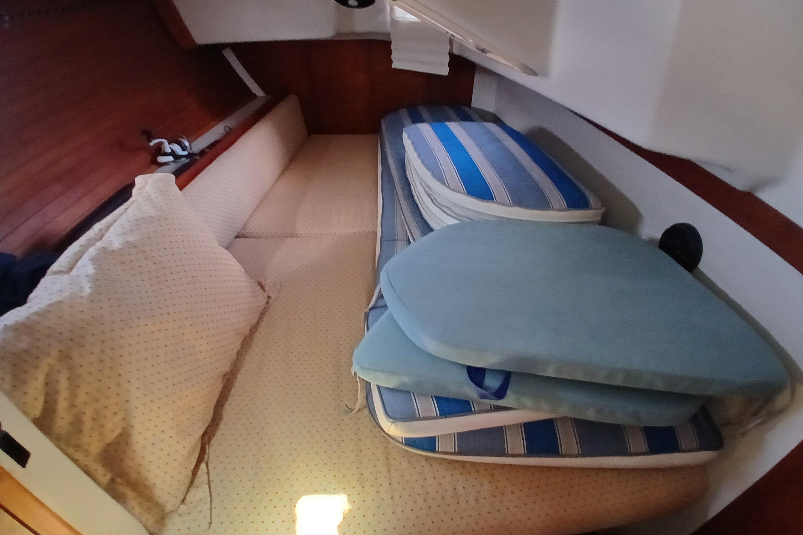 Cozy cabin interior of 1995 Catalina 42 MkII sailboat with cushions and bedding.