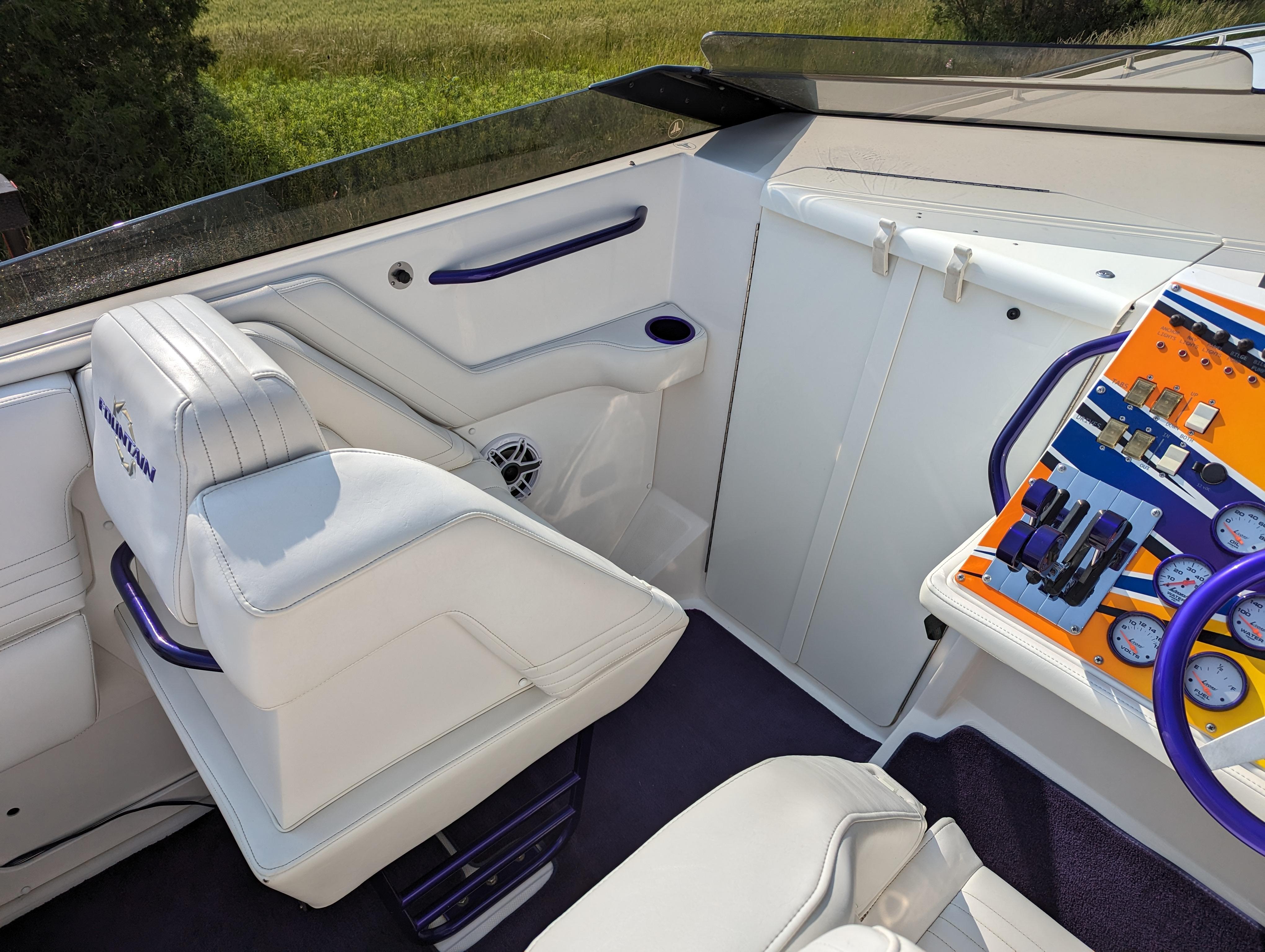 Interior of a 2006 Fountain 42 boat with white seating and colorful dashboard controls.