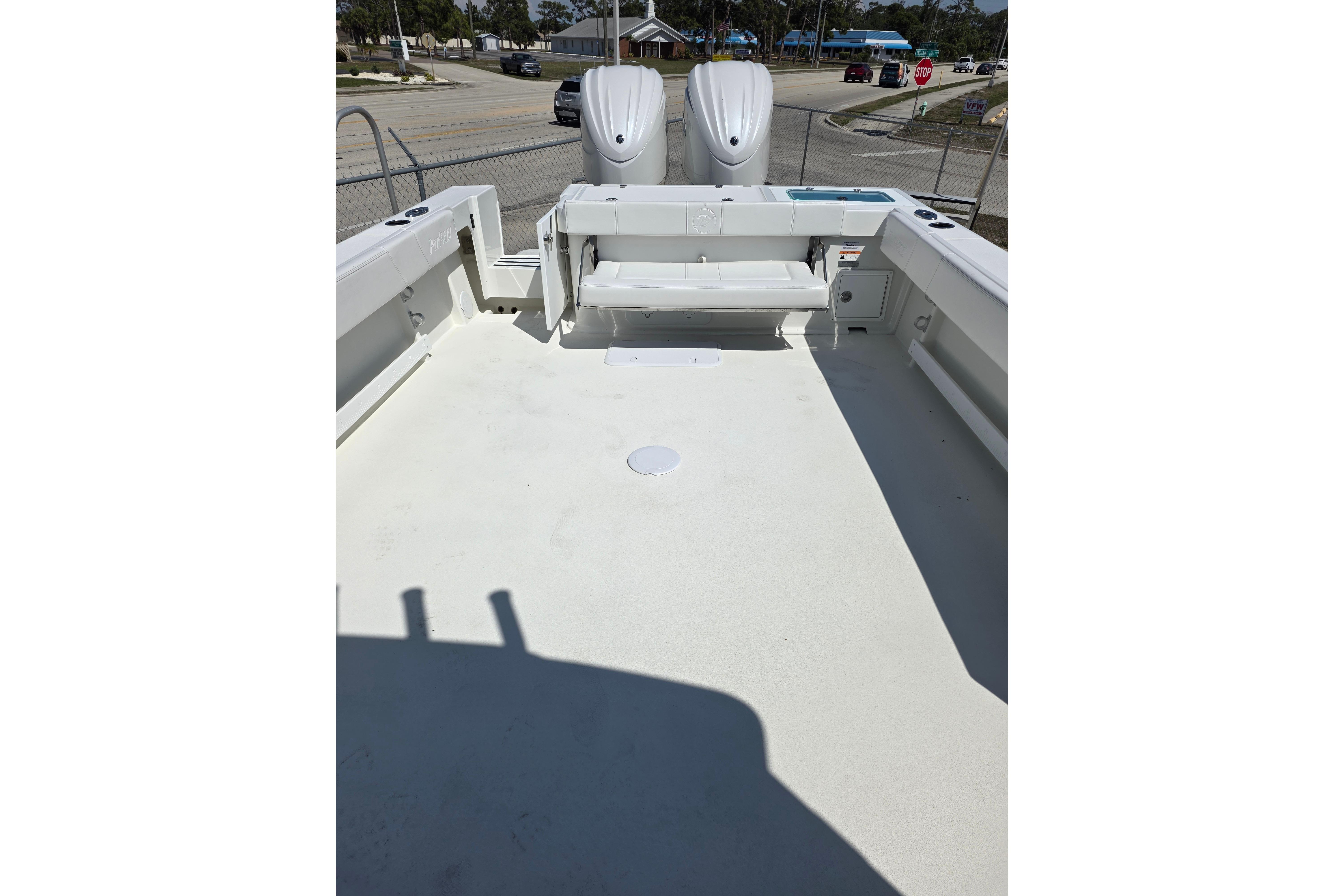 2026 Parker 287 Explorer boat deck with seating and twin engines, parked near a street.