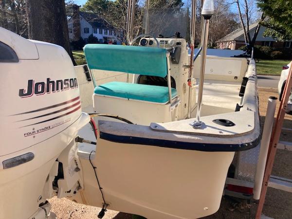 1997 Carolina Skiff 198 DLV boat with Johnson outboard motor, parked on a trailer.