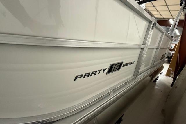 2026 Sun Tracker Party Barge 16 DLX pontoon boat side view in storage.