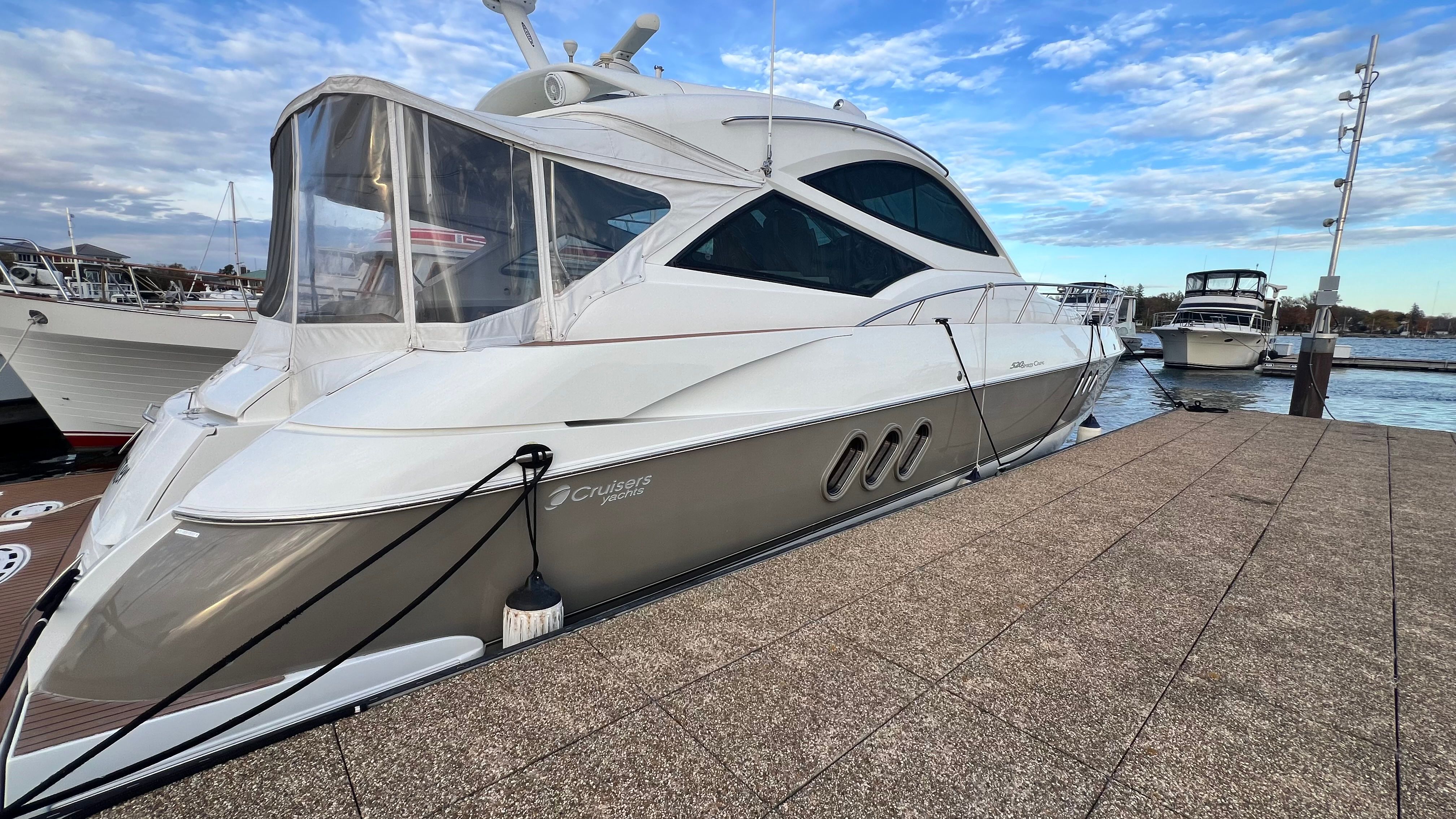 A 2009 Cruisers Yachts 520 Sports Coupe docked. The boat features a sleek design.