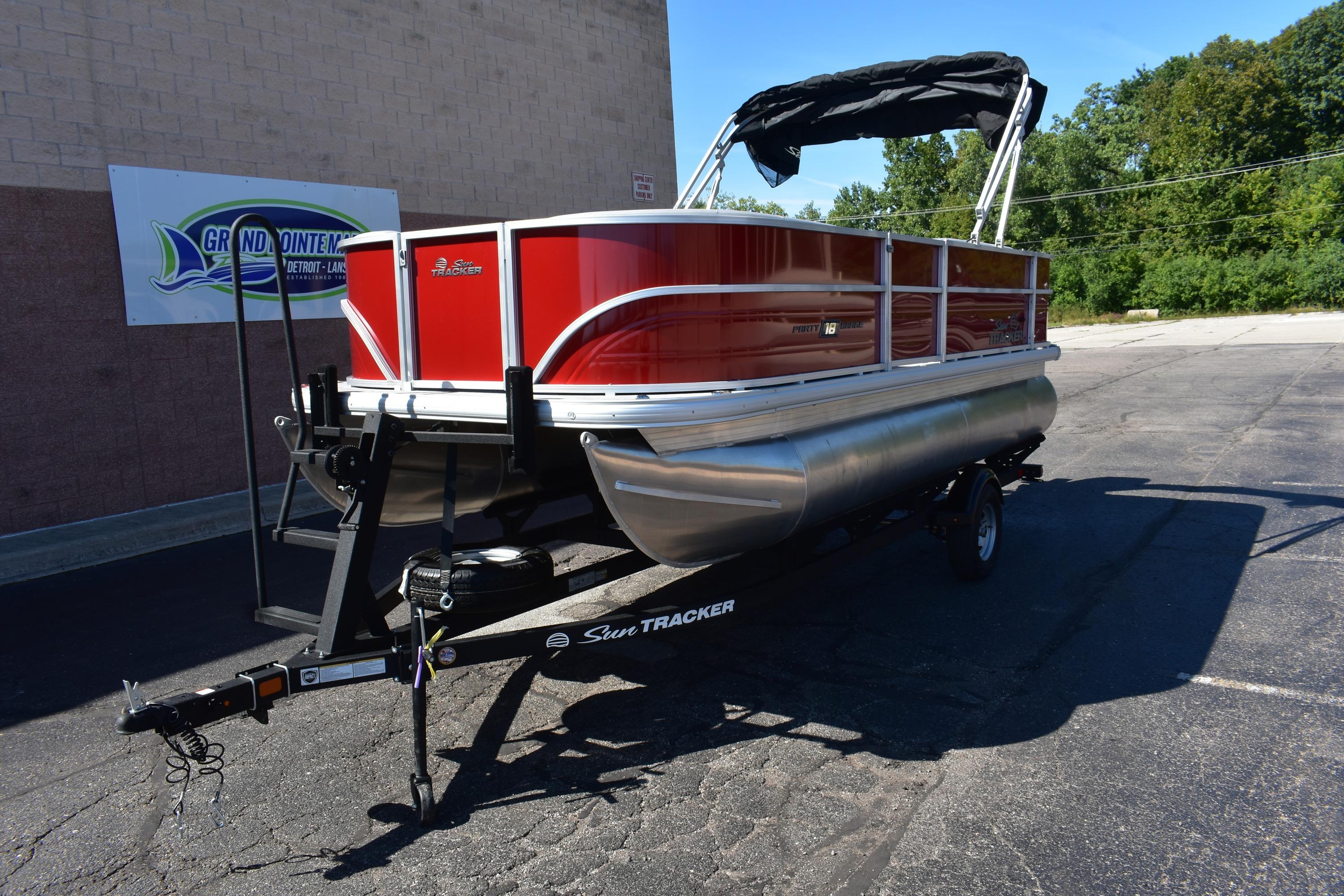 2026 Sun Tracker Party Barge 18 DLX pontoon boat on trailer, parked outdoors.