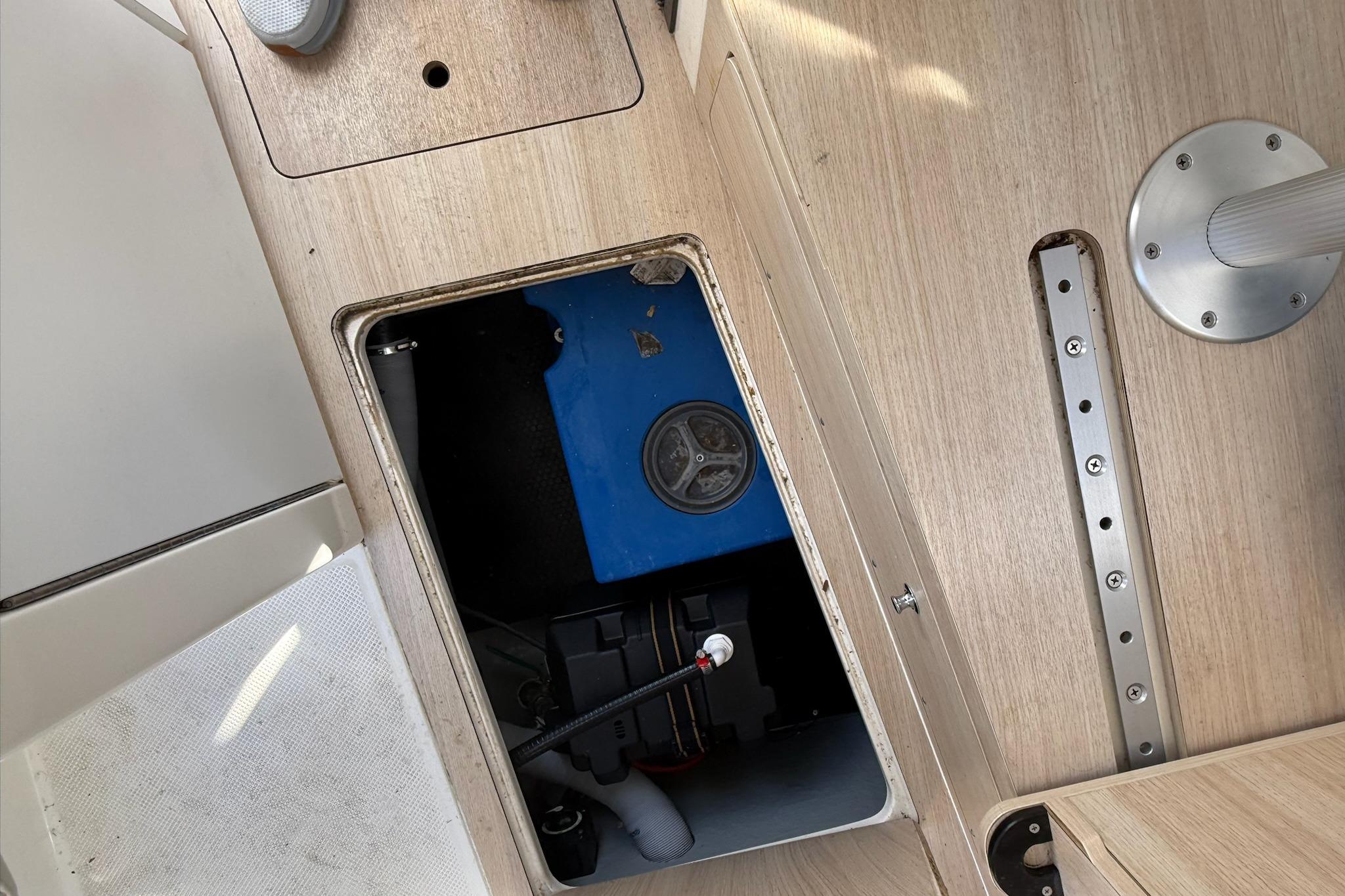 2024 Bayliner Trophy T25 Pilothouse interior compartment with blue equipment and wooden finish.