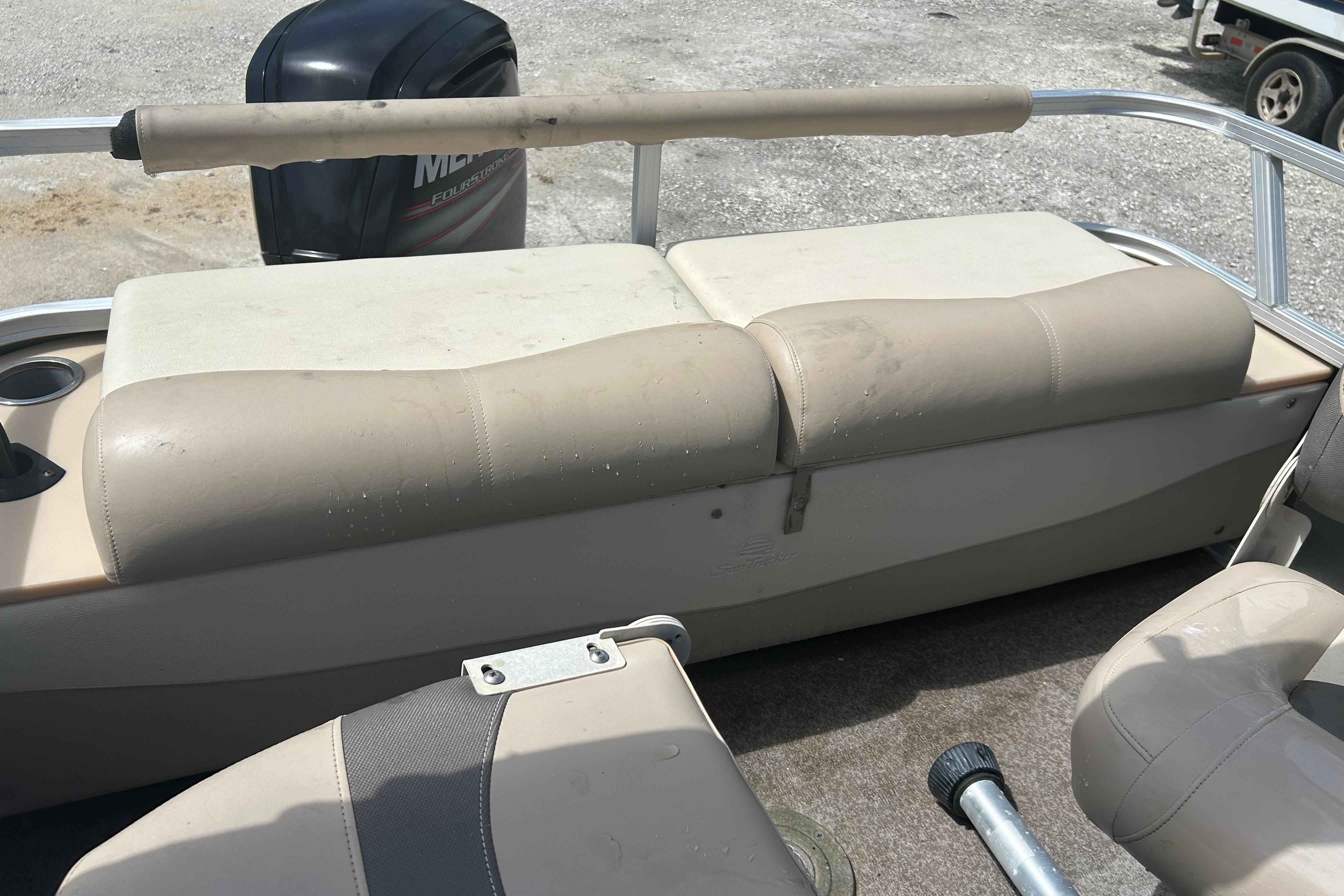 2015 Sun Tracker Party Barge 22 Tritoon interior with beige seating and Mercury outboard motor.