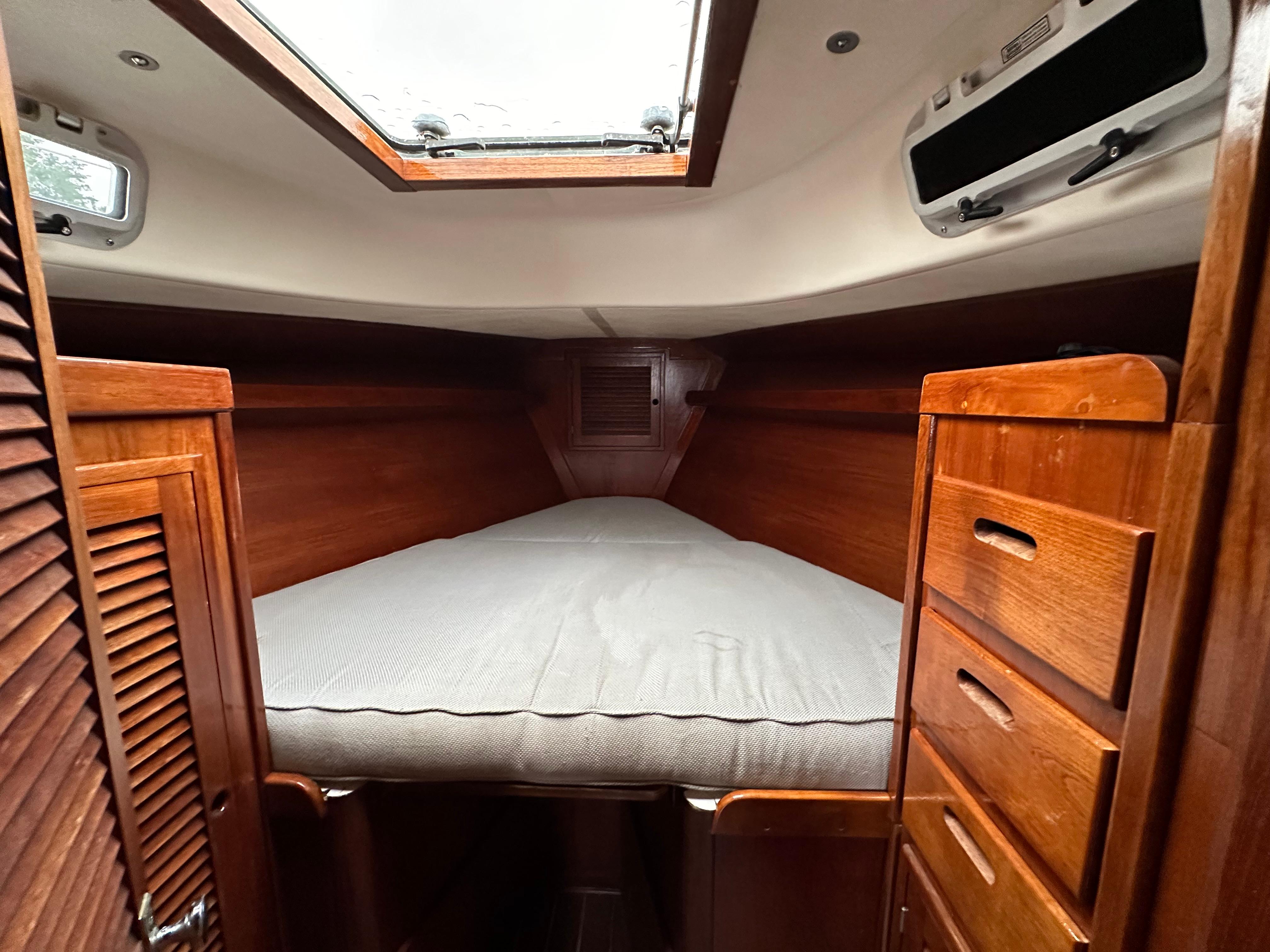 Cozy cabin interior of 1981 Tartan 37 sloop with wooden finish and overhead hatch.