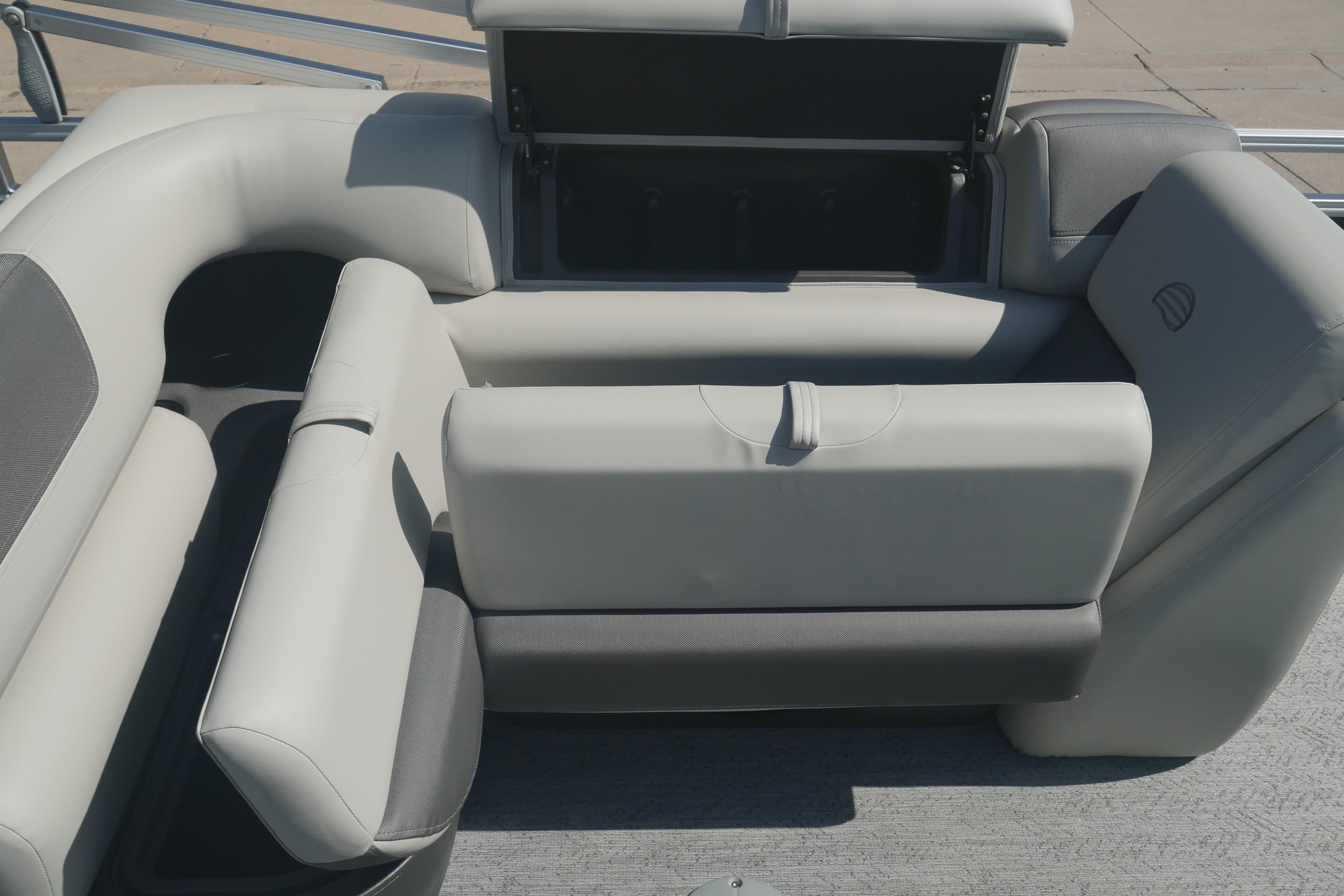 2026 Sun Tracker Fishin' Barge 20 DLX interior seating with storage compartment open.