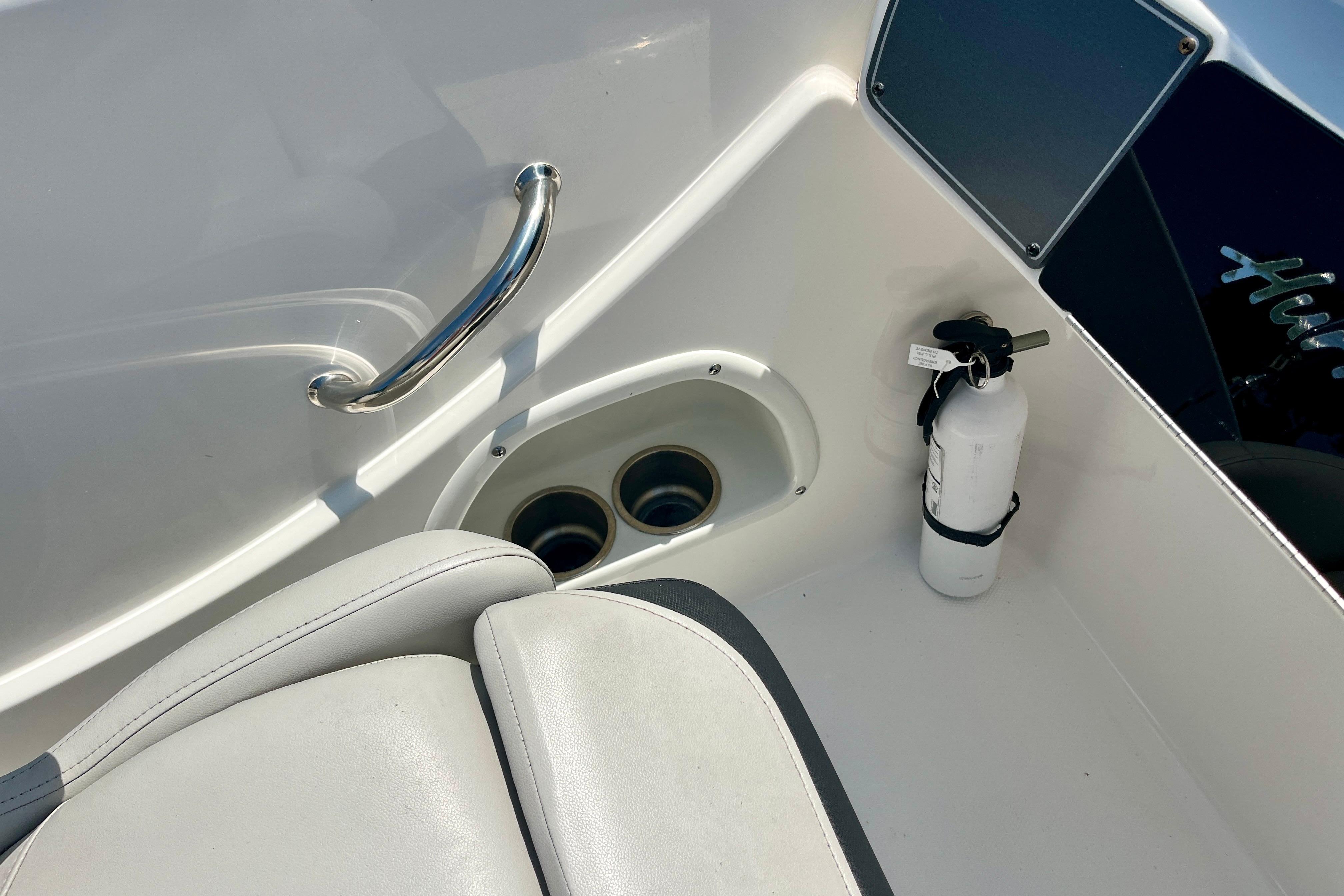2024 Hurricane Sundeck Sport 218 OB interior with seat, cup holders, and fire extinguisher.