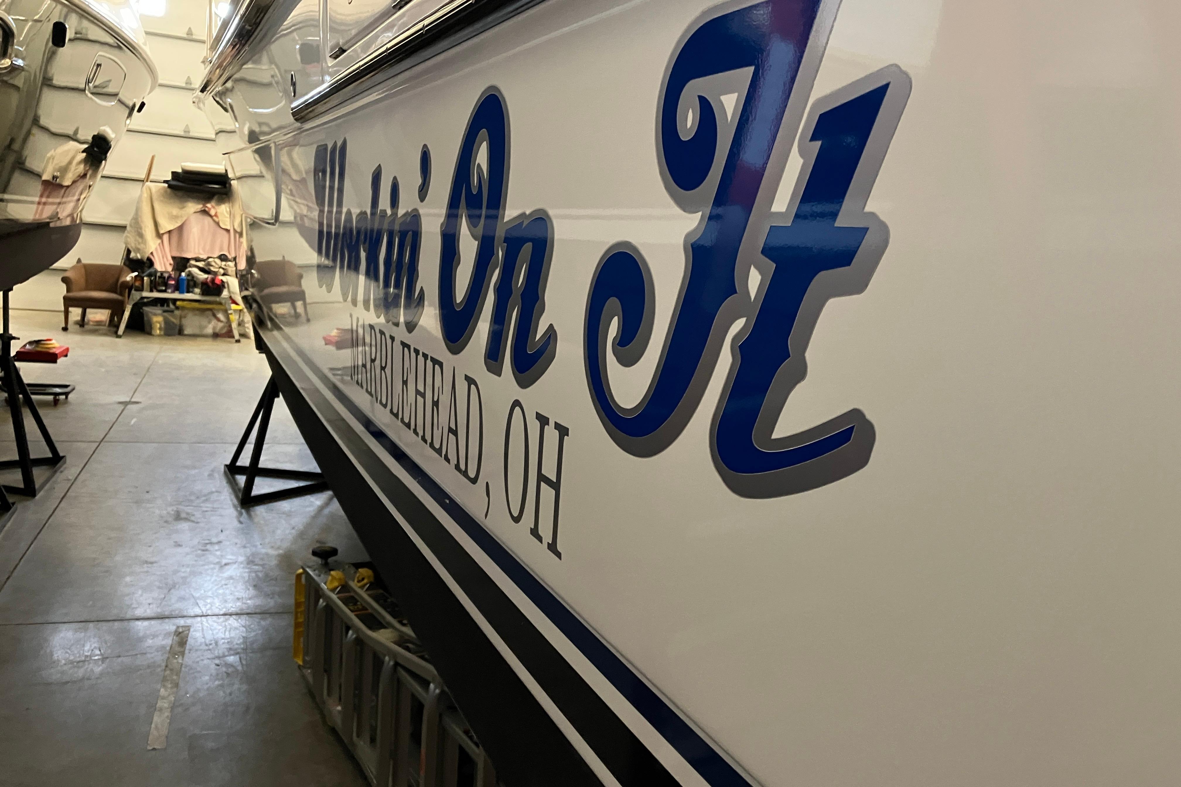 2017 Cutwater C-30 Sedan boat in a garage, featuring "Workin' On It" text.
