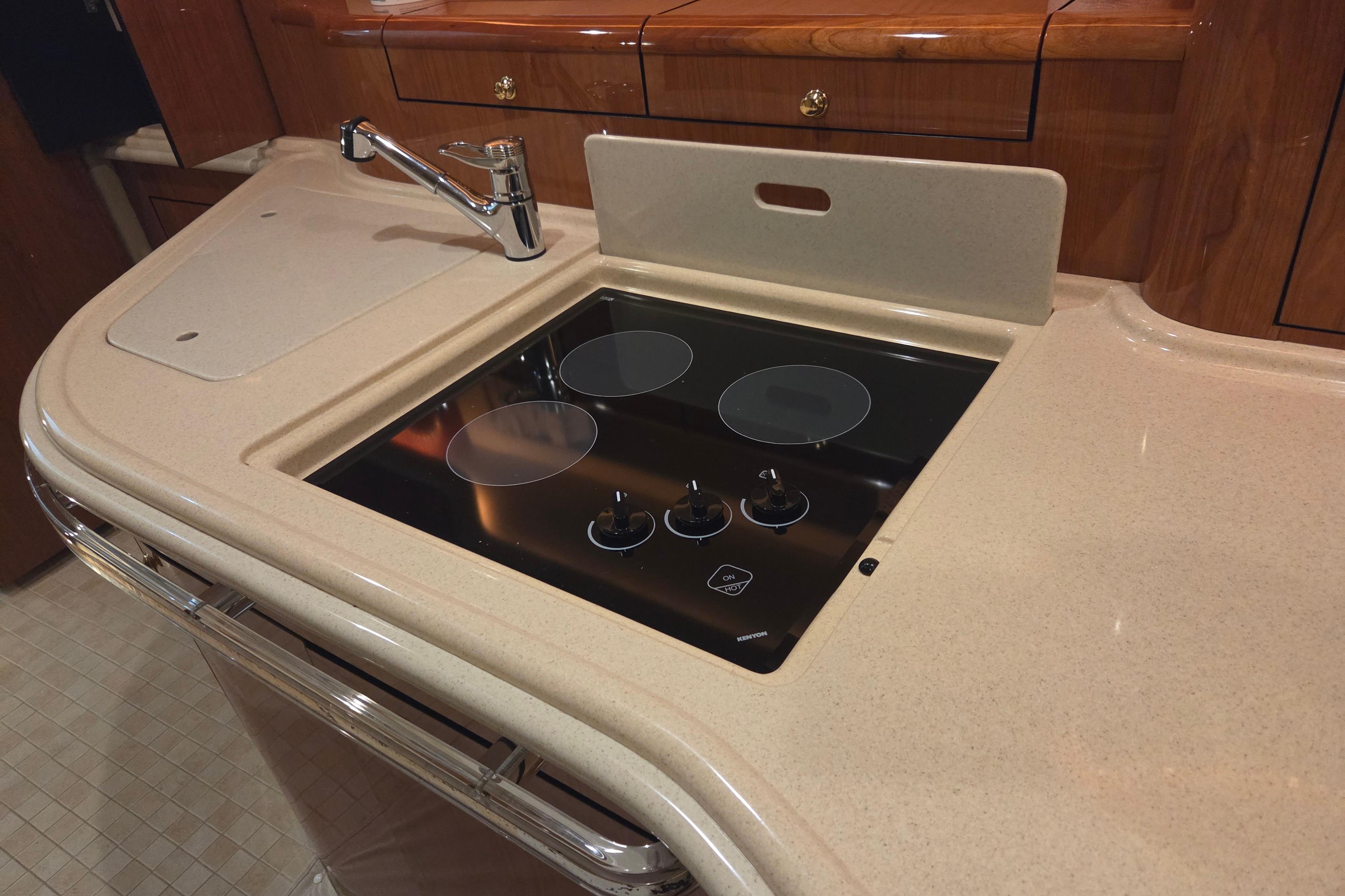 Luxurious kitchen area in 2000 Sea Ray Sundancer 540 yacht with stovetop and sink.