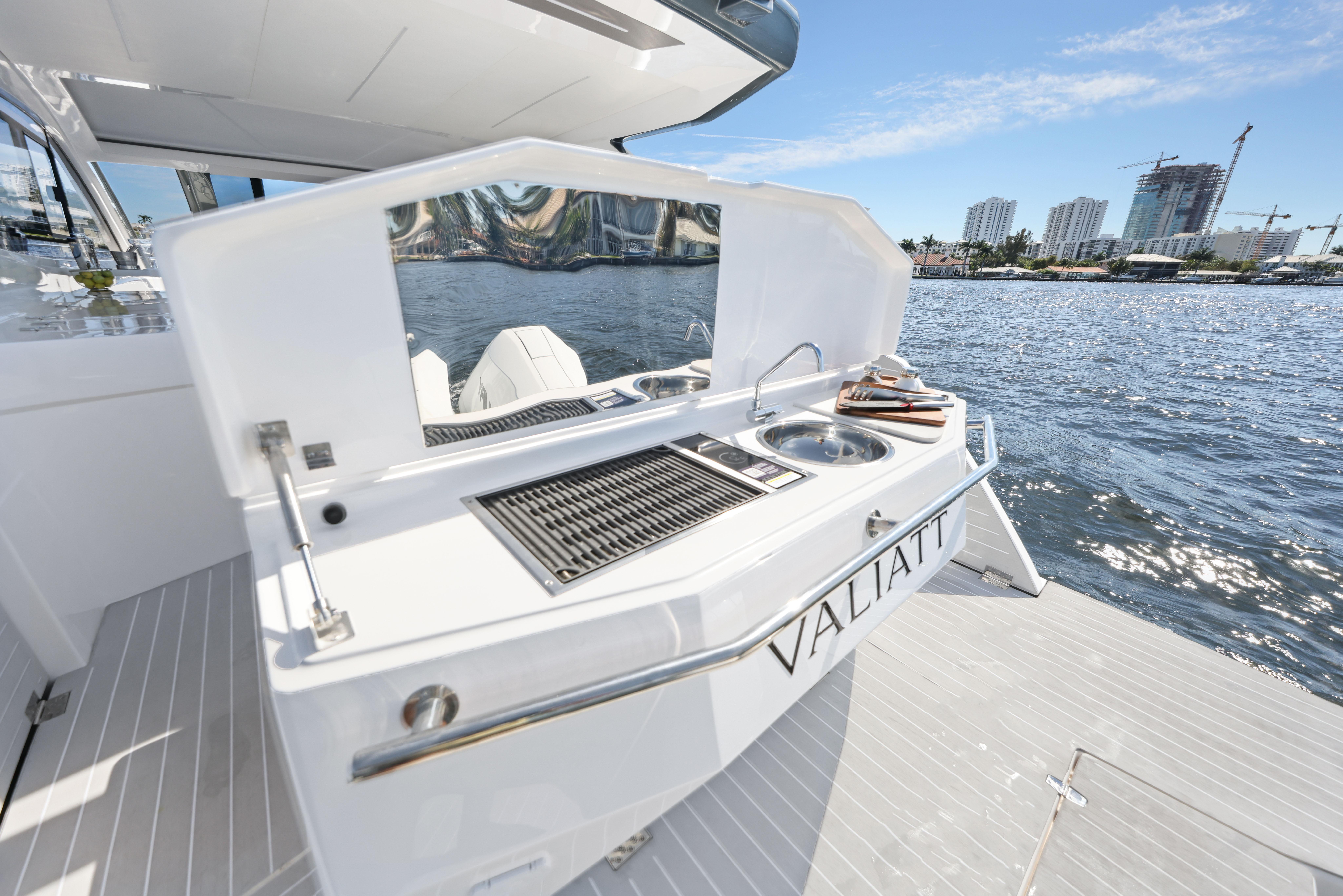 2025 Valiatt 380 Bowrider boat with outdoor kitchen, docked by waterfront cityscape.
