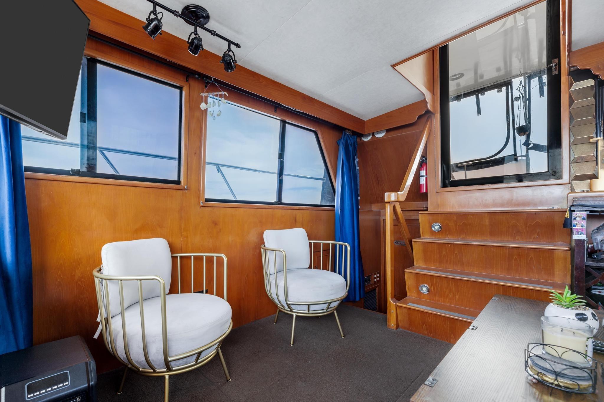 1988 Marine Trader Trawler interior with modern chairs, wooden paneling, and large windows.