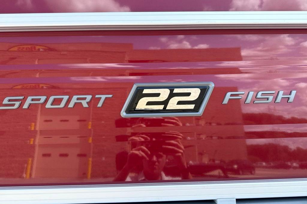 2026 Sun Tracker SportFish 22 DLX logo on a red surface.