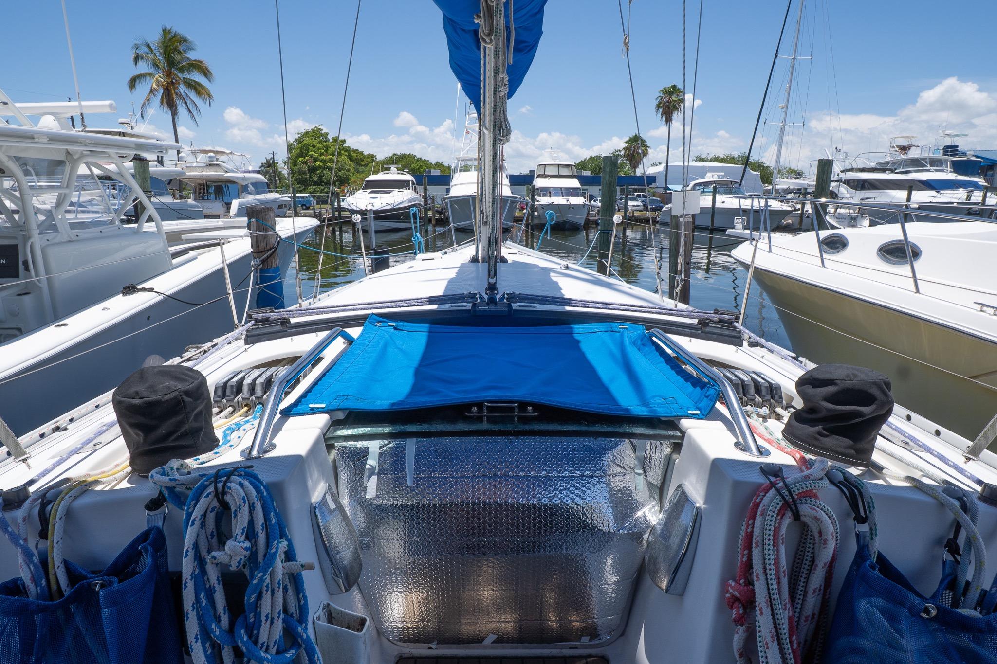 1993 Beneteau First 38 s5 sailboat docked at marina, surrounded by other boats.