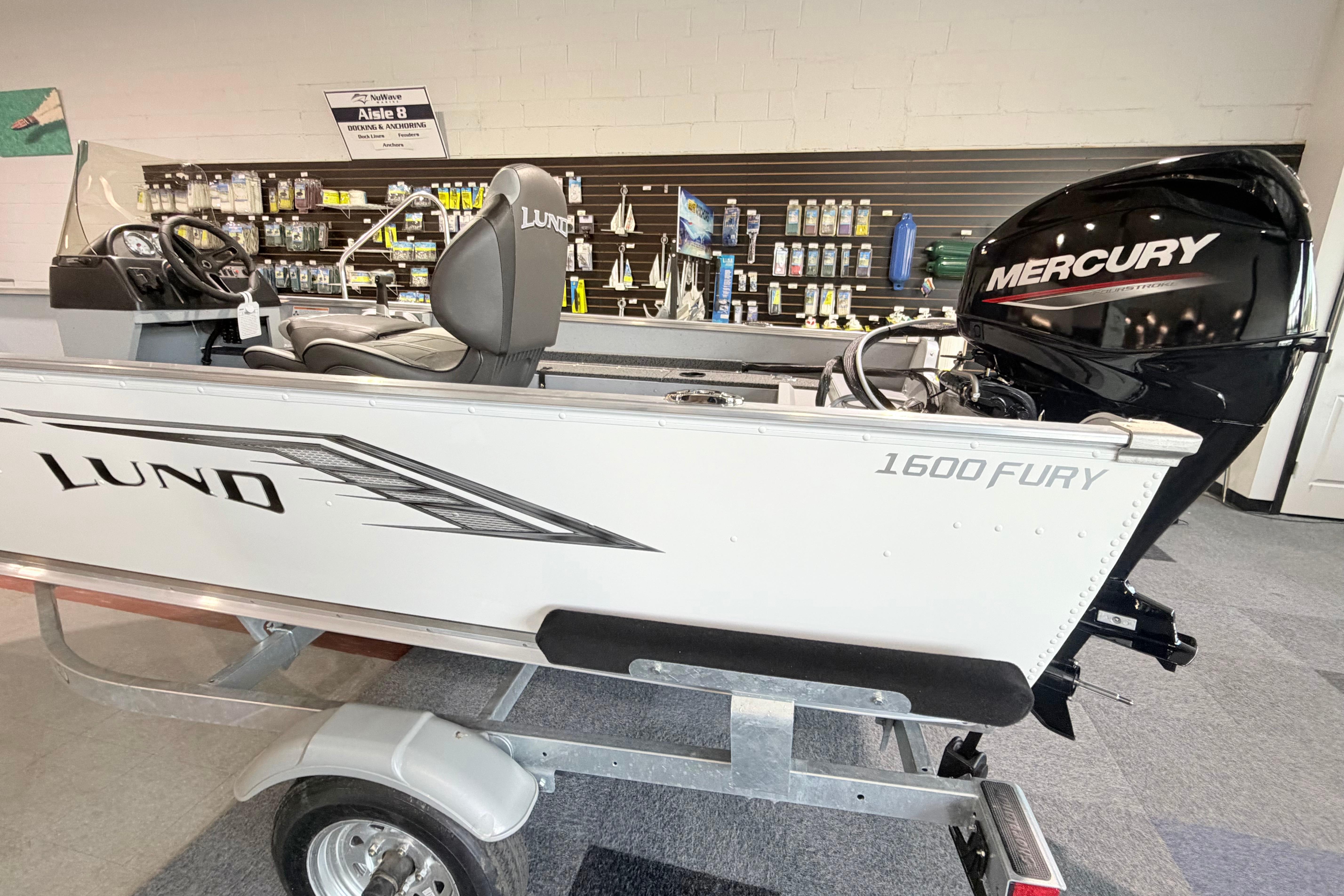 2027 Lund 1600 Fury SS boat with Mercury engine displayed in a showroom.