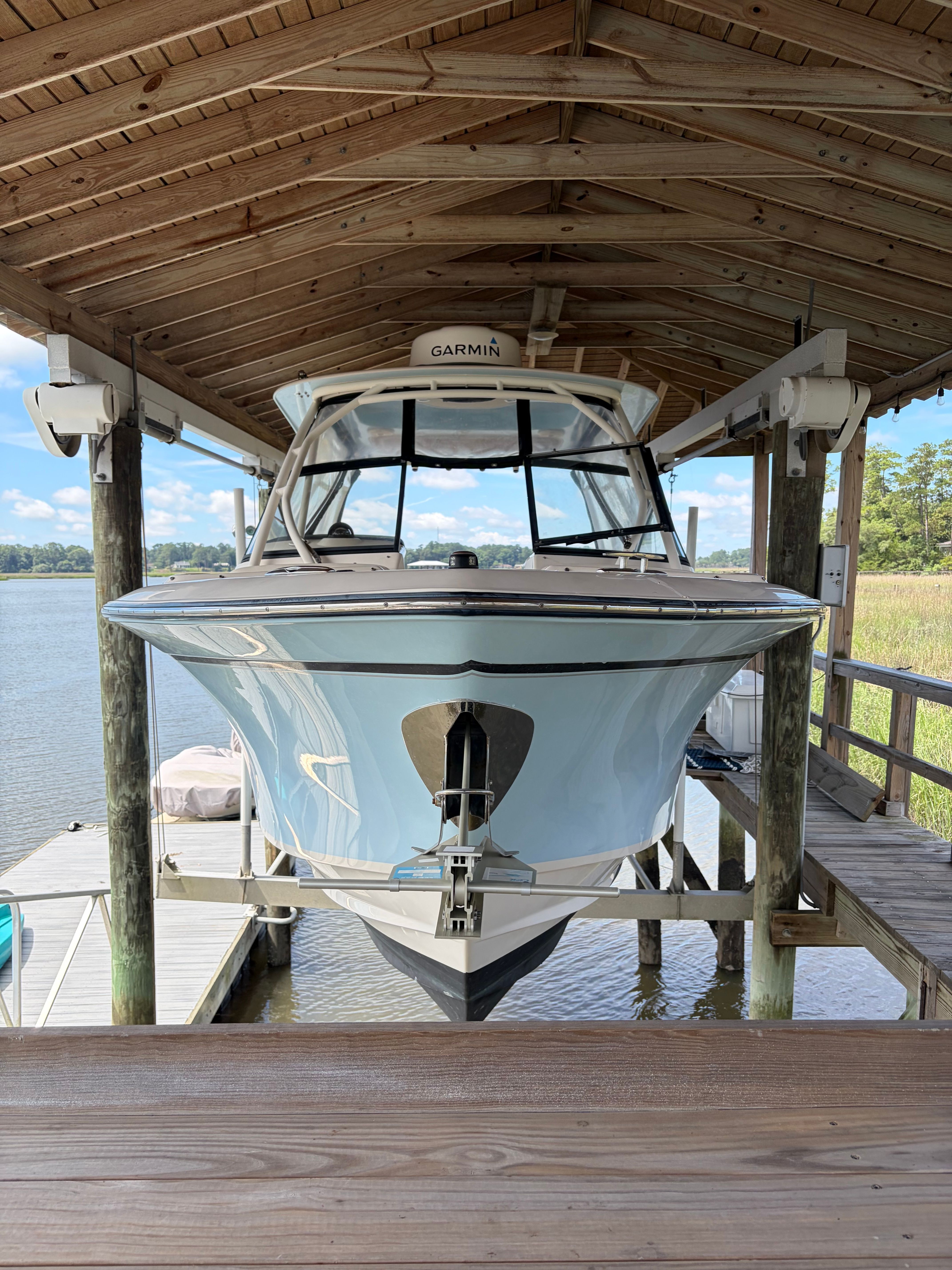 A 2016 Grady-White Freedom 275 boat is docked in a covered boathouse.