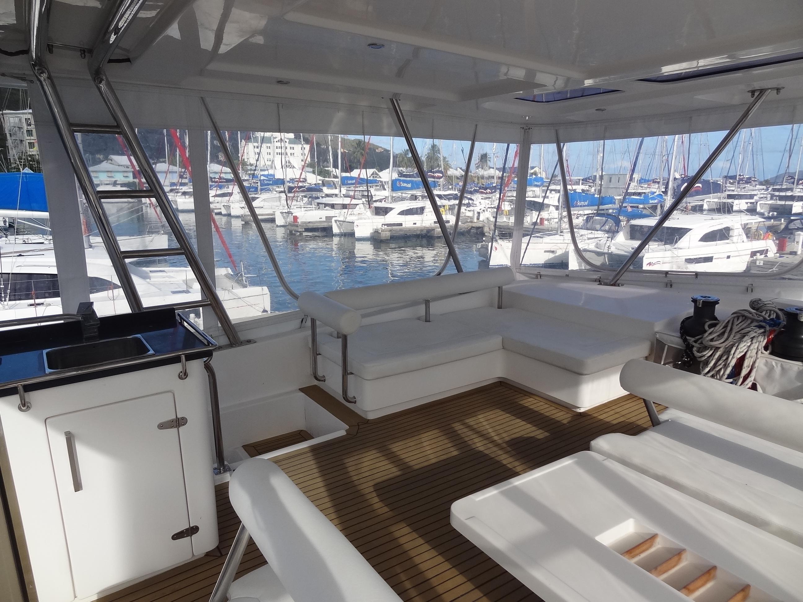 Leopard 58 yacht 2014 model, spacious deck with white seating, docked at marina.
