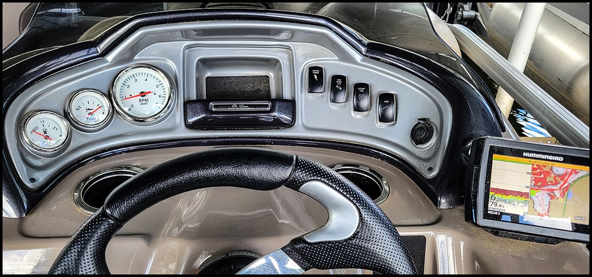 Dashboard of a Sun Tracker Party Barge 20 DLX with steering wheel and navigation system.