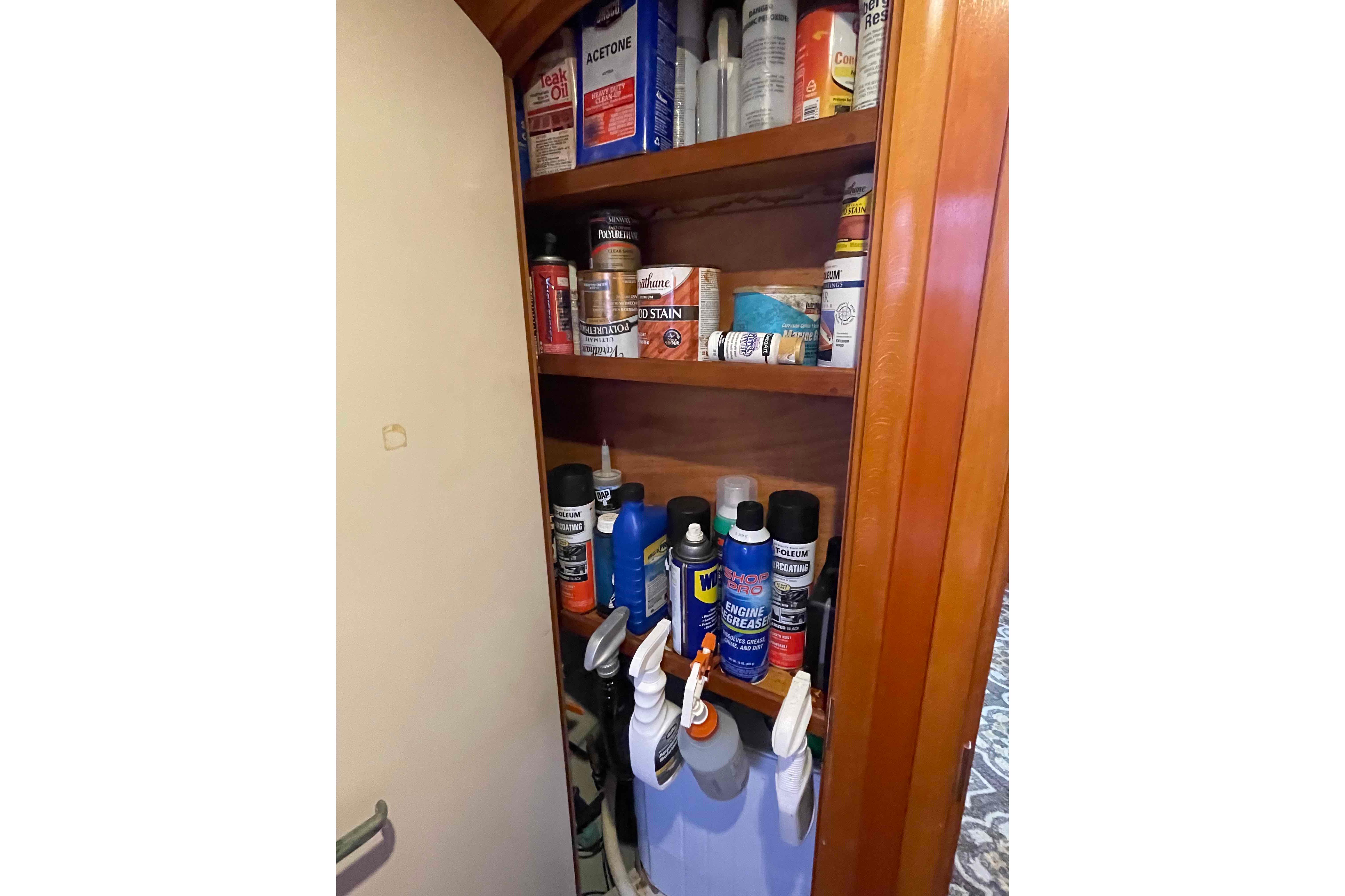 Storage cabinet with various maintenance supplies on a 2003 Lagoon 410-S2 yacht.