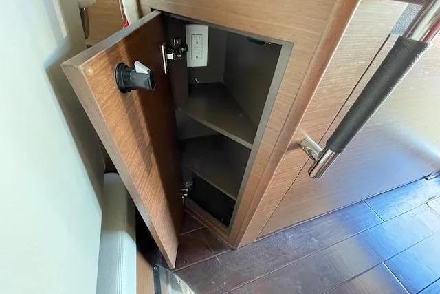 Open wooden cabinet with shelves and electrical outlet on Sea Ray Sundancer 510 yacht, 2016 model.