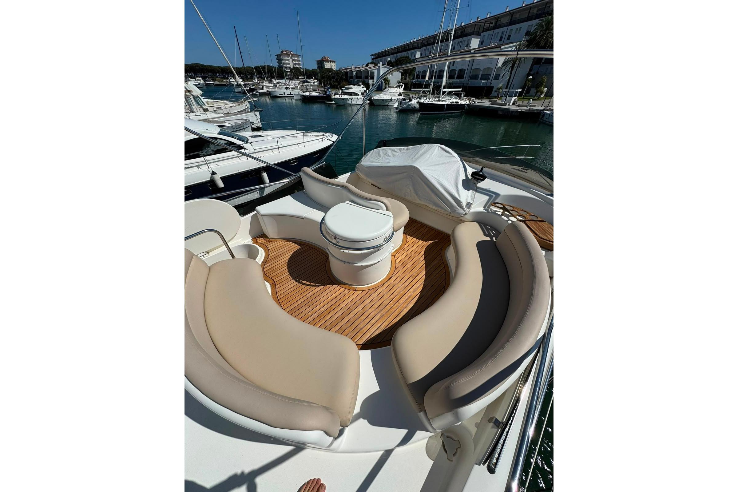 Luxurious 2007 Azimut 46E yacht with elegant seating and teak deck in marina.