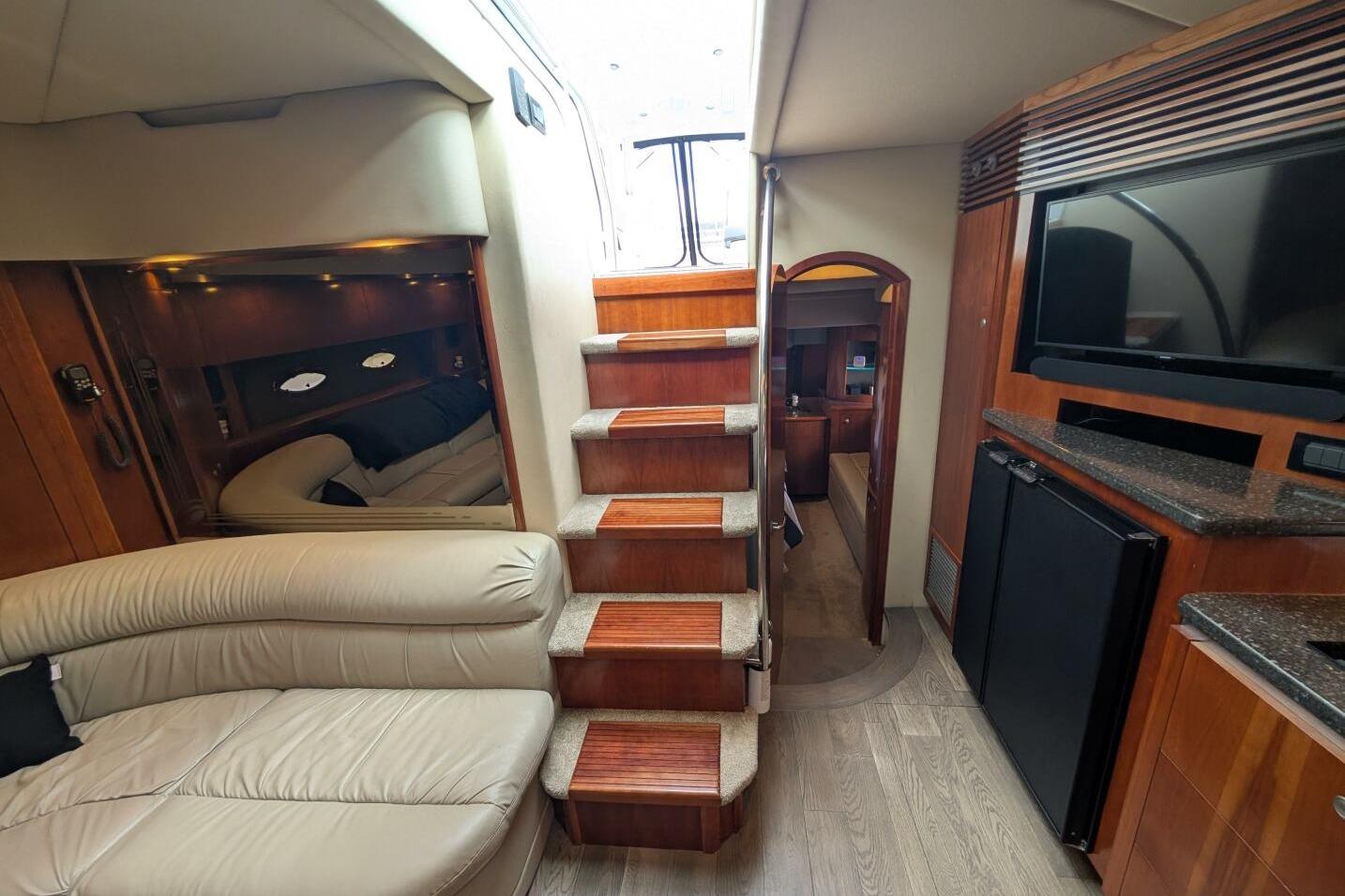 Luxurious interior of 2007 Cruisers Yachts 520 Express with stairs, seating, and entertainment area.