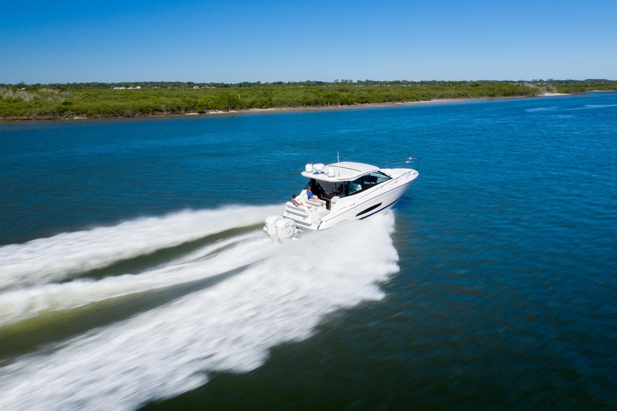 2026 Regal 36 XO boat cruising on a clear blue lake under a sunny sky.