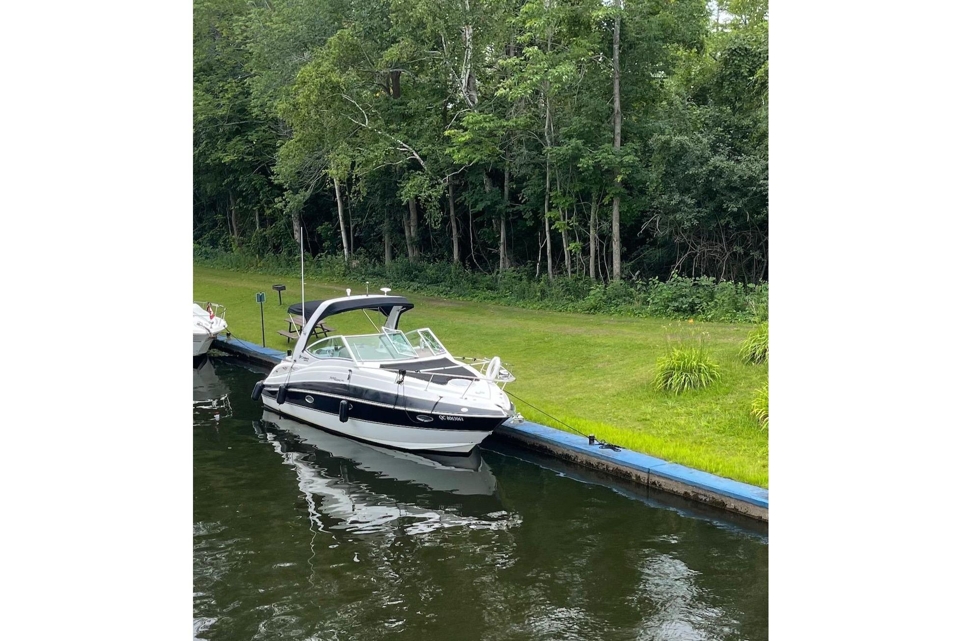 2011 Cruisers Yachts 300 Express docked by lush greenery.