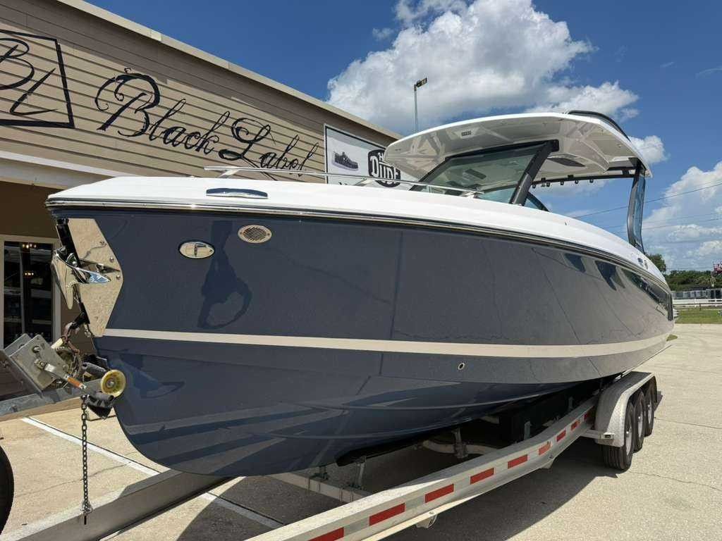 A 2026 Monterey Elite 30 OB boat on a trailer in front of a building.